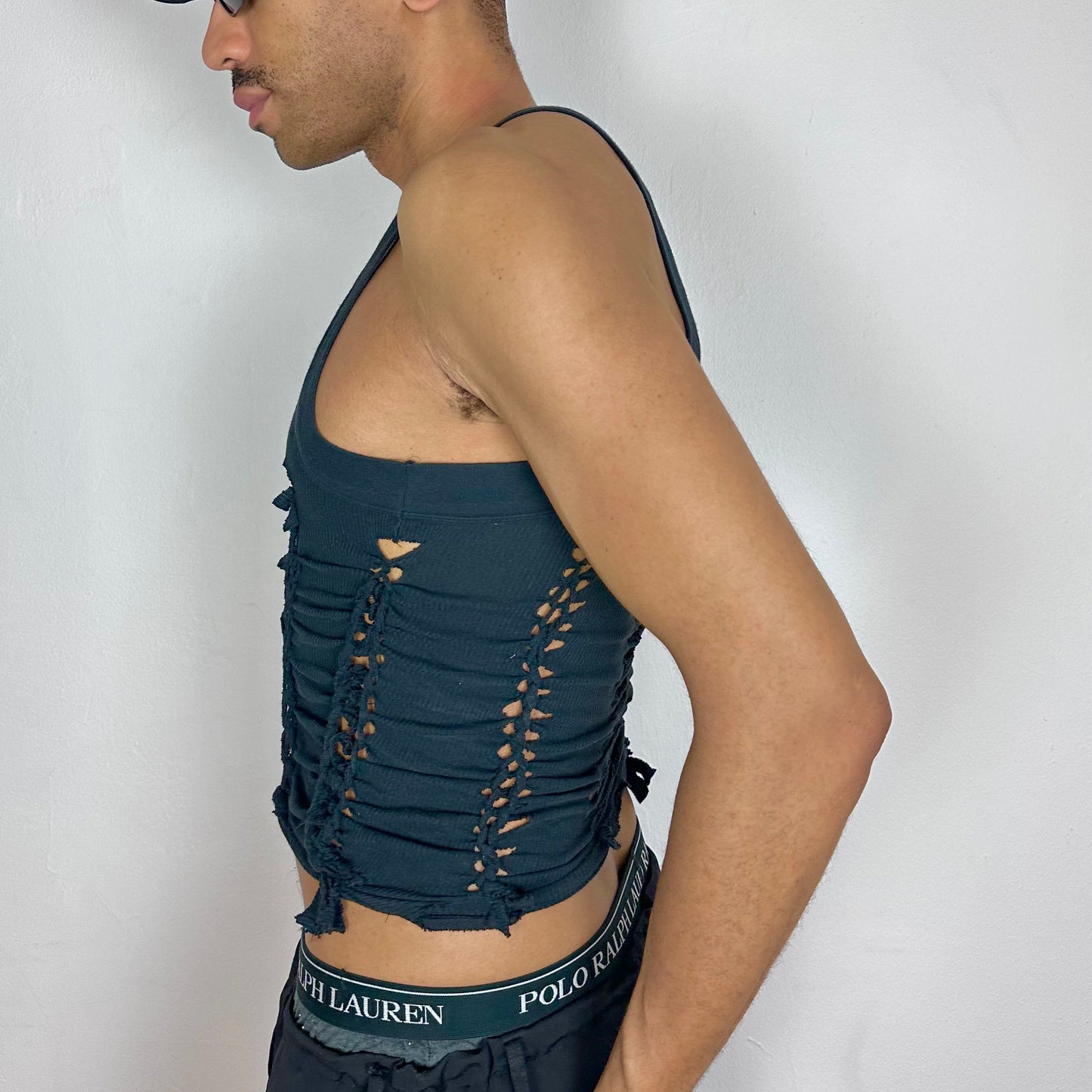 Left side detail of ASTROBOI* 'Abstract' showing hand-braided arrangement and cut-out detailing along front and back on black Y2K tank.