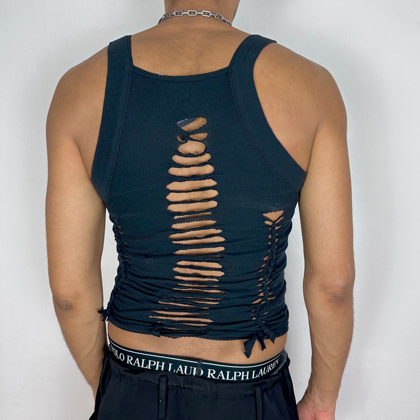 ASTROBOI* 'Abstract' black braided cut out Y2K tank top, rear view showing intricate braid and cut-out construction along back, worn by male model.