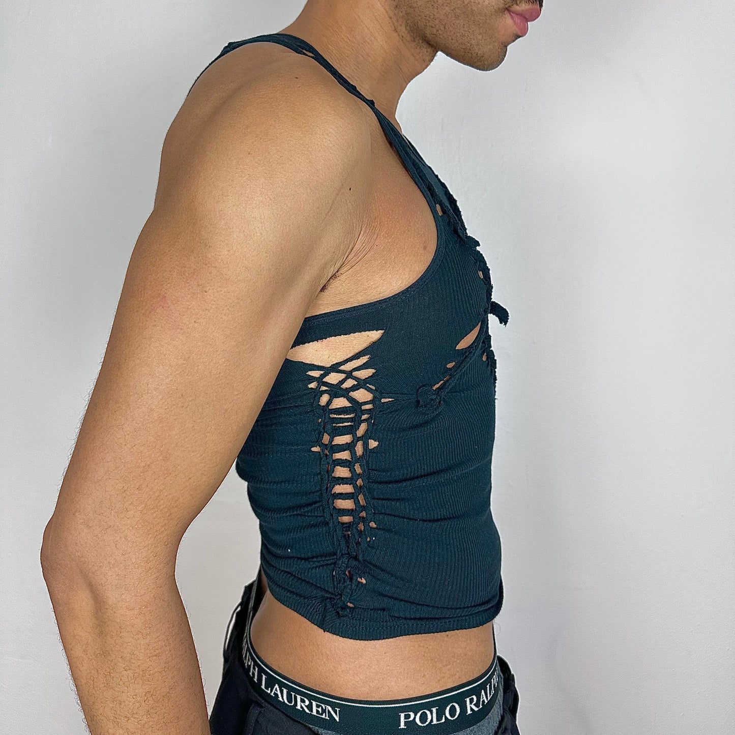 Right side detail of ASTROBOI* x Gildan 'Octavos' showing asymmetric strap, braided twist, and knot construction on slim-fitting black base.