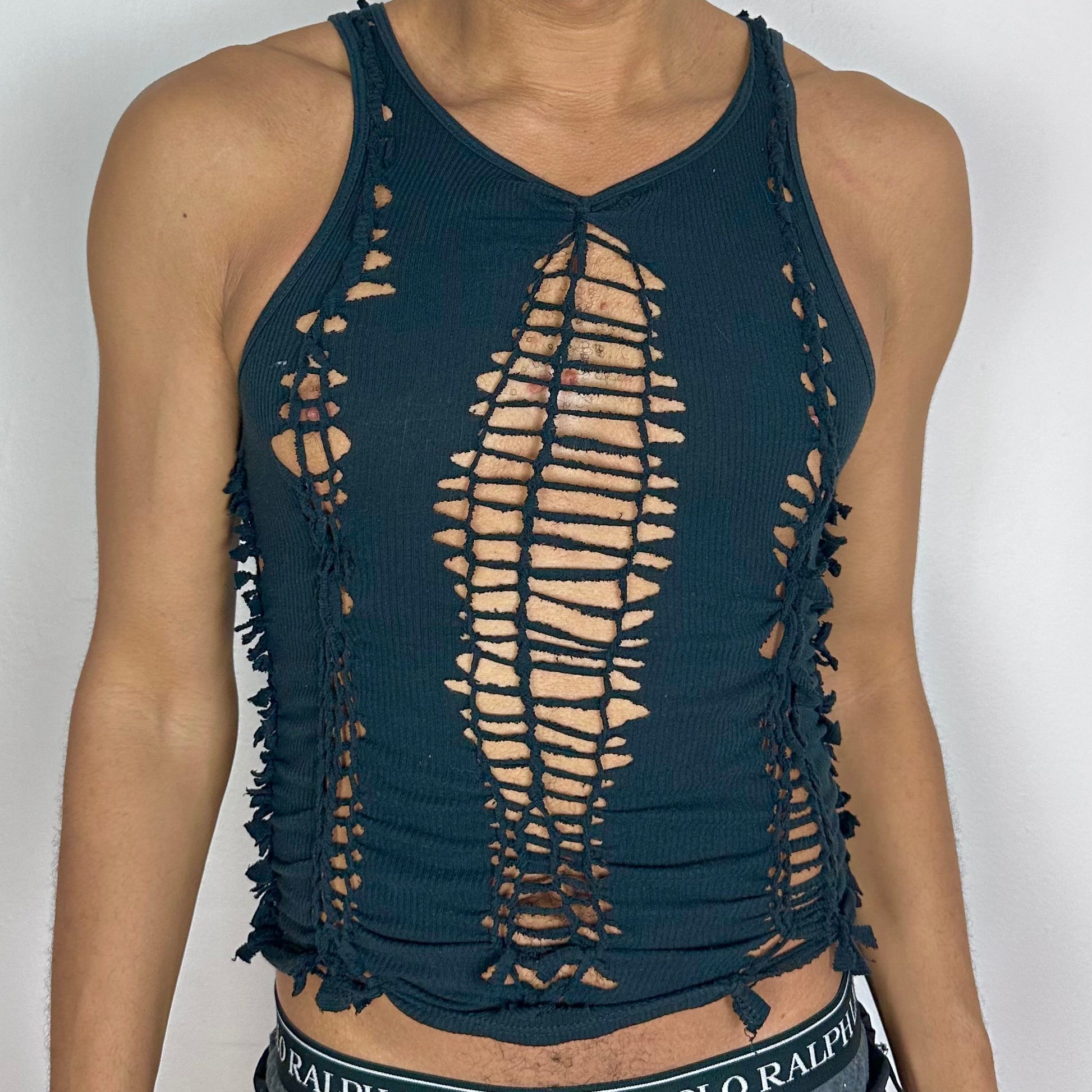 Close-up of ASTROBOI* 'Jet' showing hand-braided construction, knot, and cut-out detailing on black stretch cotton fabric.
