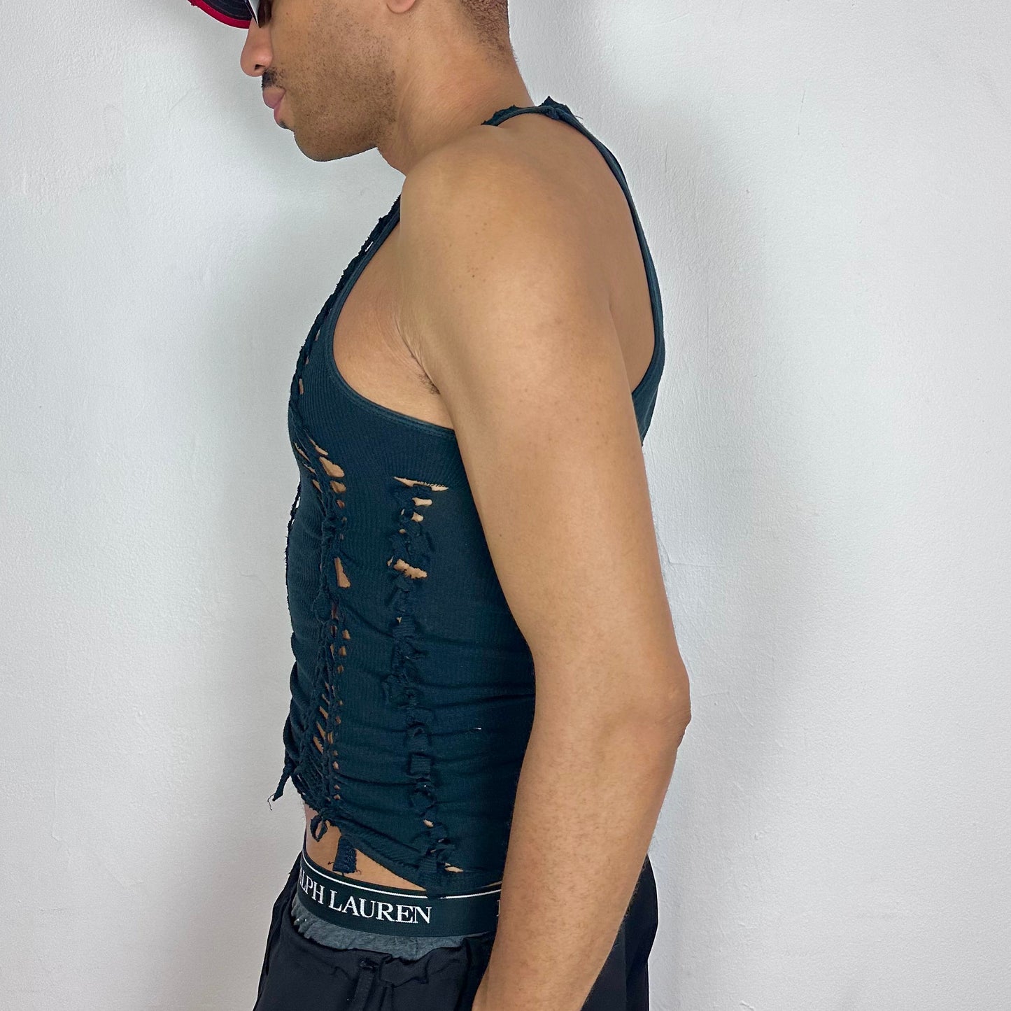 Left side detail of ASTROBOI* 'Jet' showing hand-braided arrangement, knot detail, and cut-outs on black stretch cotton tank.