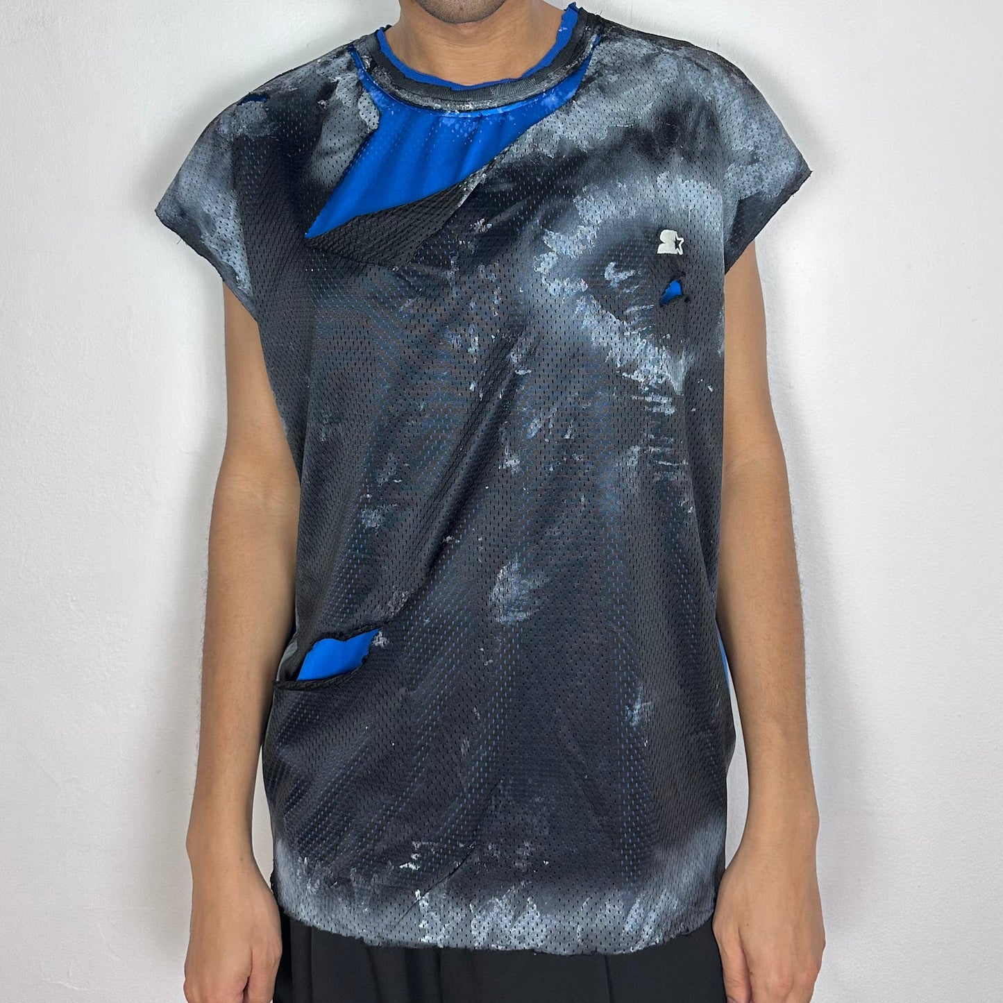 ASTROBOI* x Starter black and blue ripped mesh tank top with artfully ripped outer mesh revealing blue interior layer, white paint detailing, and Starter logo at chest, baggy fit, front view.