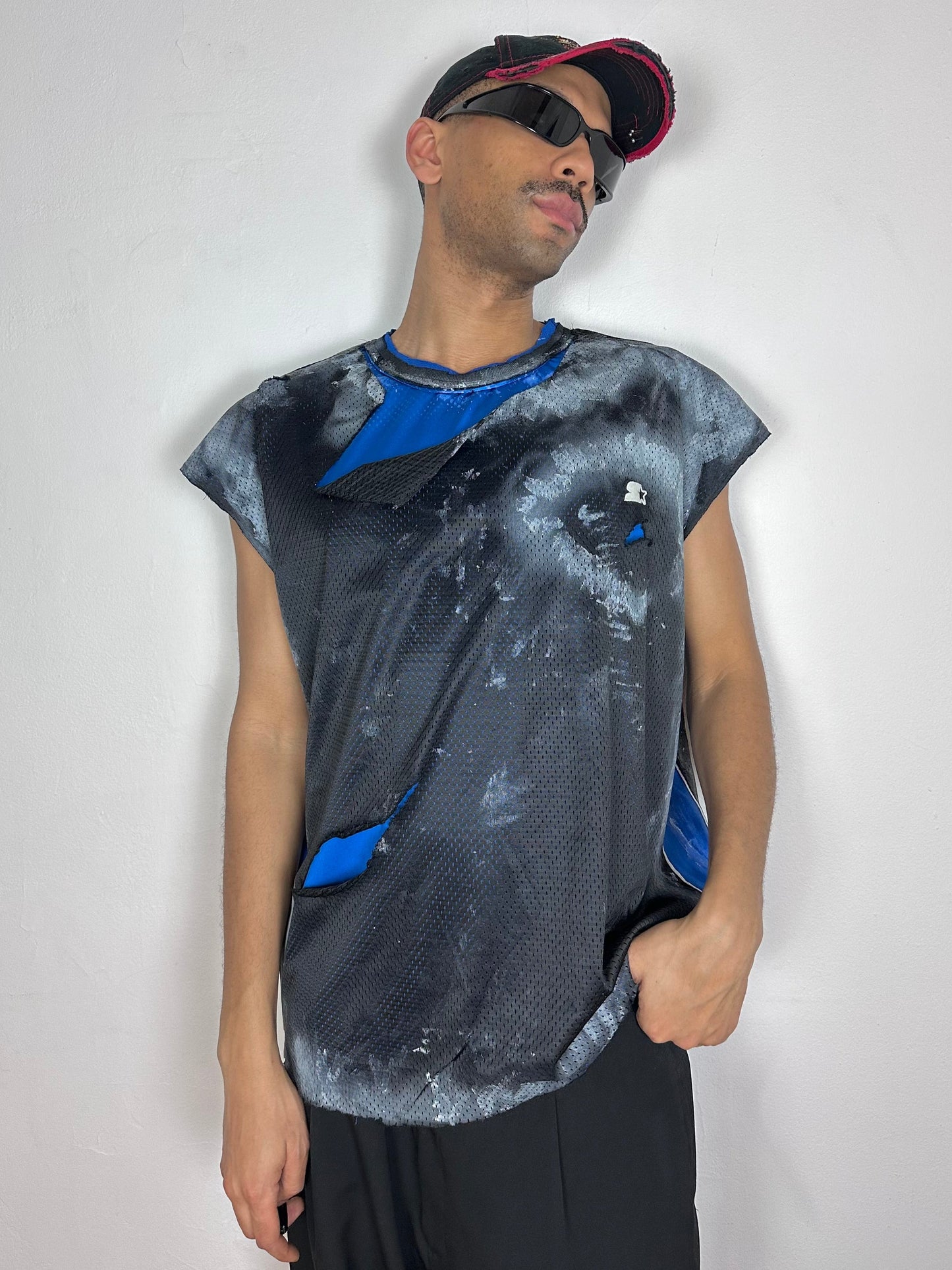 Male model wearing ASTROBOI* x Starter black and blue ripped mesh tank top, styled full look, ASTROBOI* STUDIO NYC.