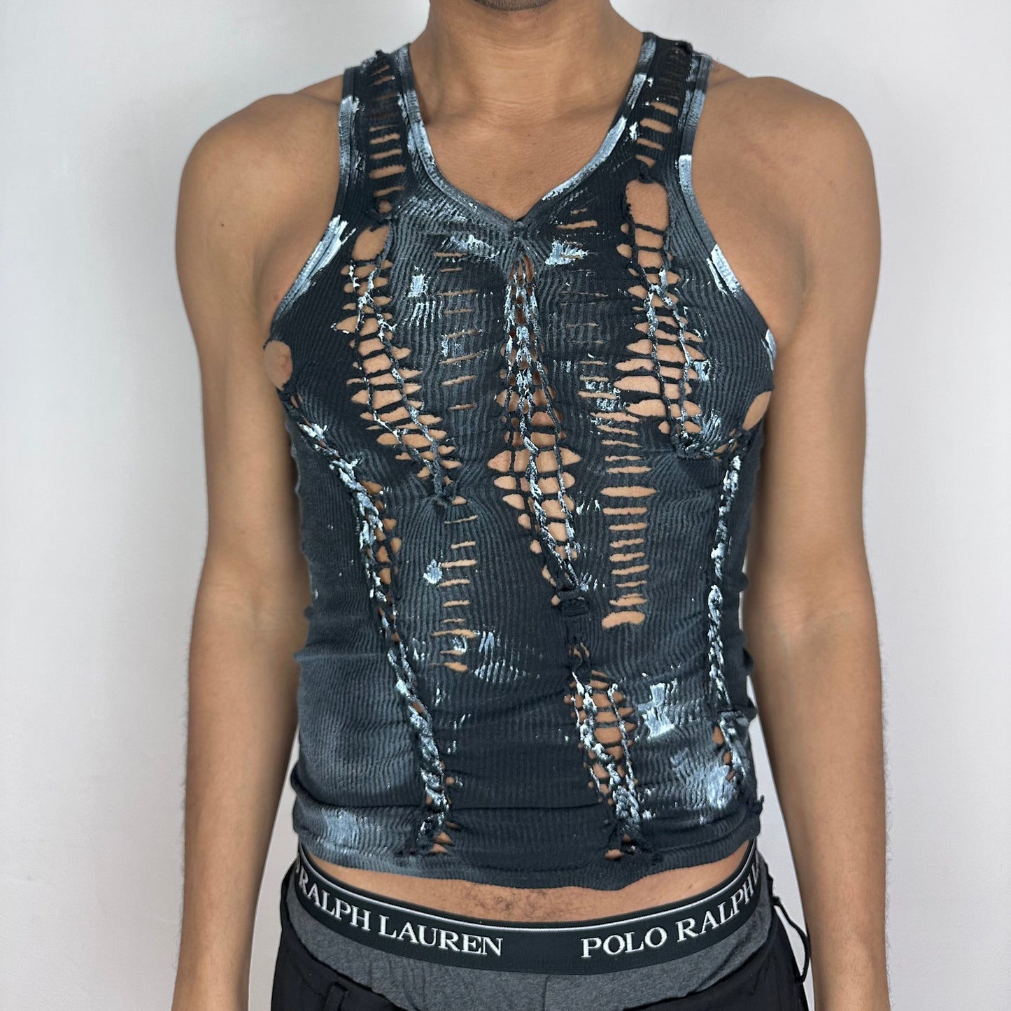 ASTROBOI* x Gildan 'White Out' black close-fitting braided twist tank top with cut-outs and white paint design throughout, front view.