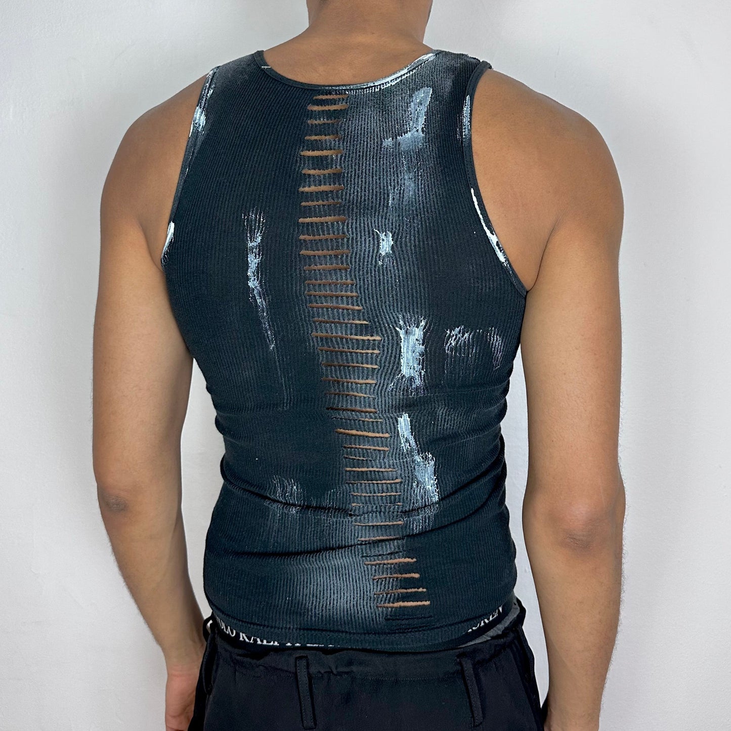 ASTROBOI* x Gildan 'White Out' black and white braided twist tank top, rear view showing braid, cut-out, and paint detail construction, worn by male model.