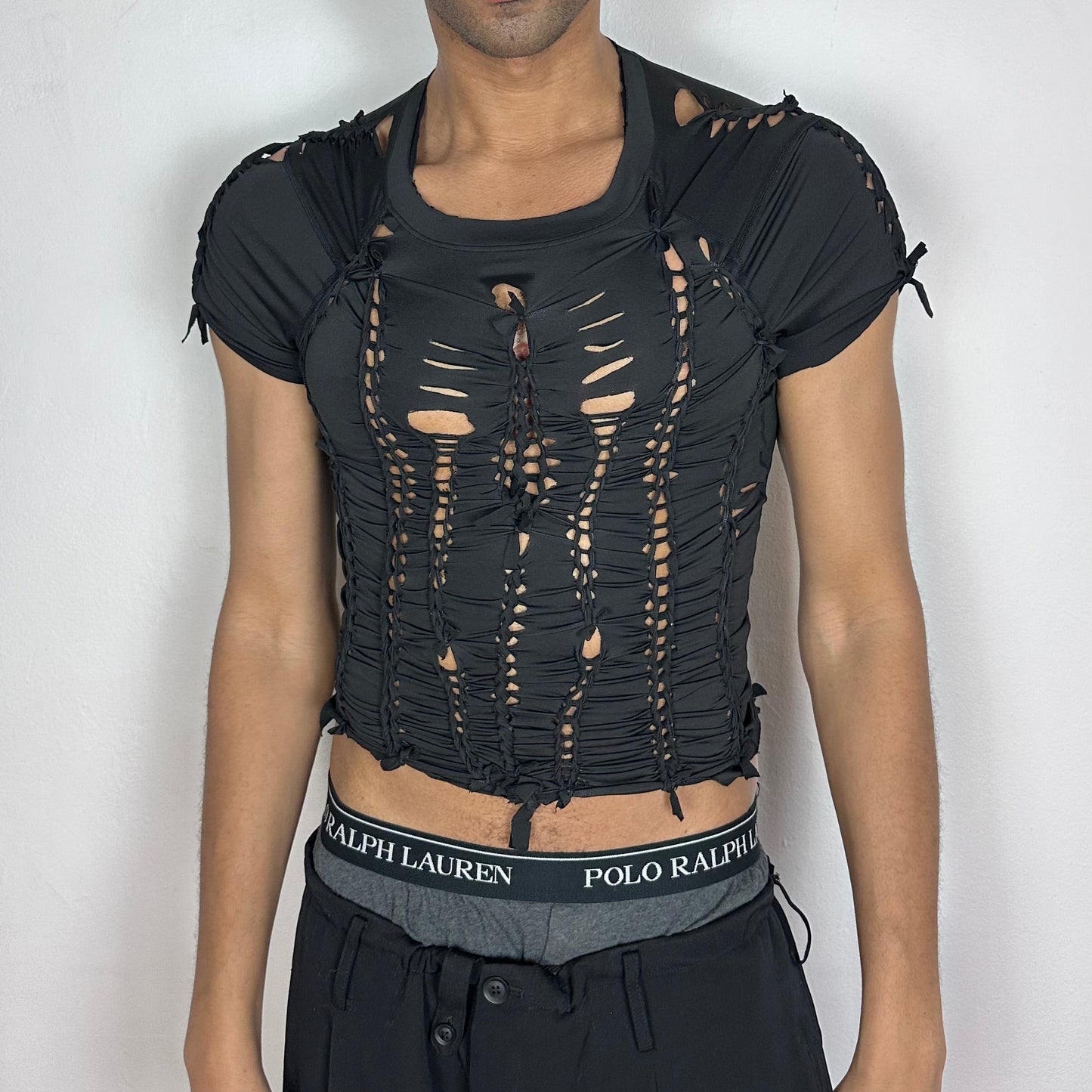 ASTROBOI* 'Pandora' black slim-fitting short sleeve braided compression crop top with hand-braided arrangement and cut-outs throughout, front view.