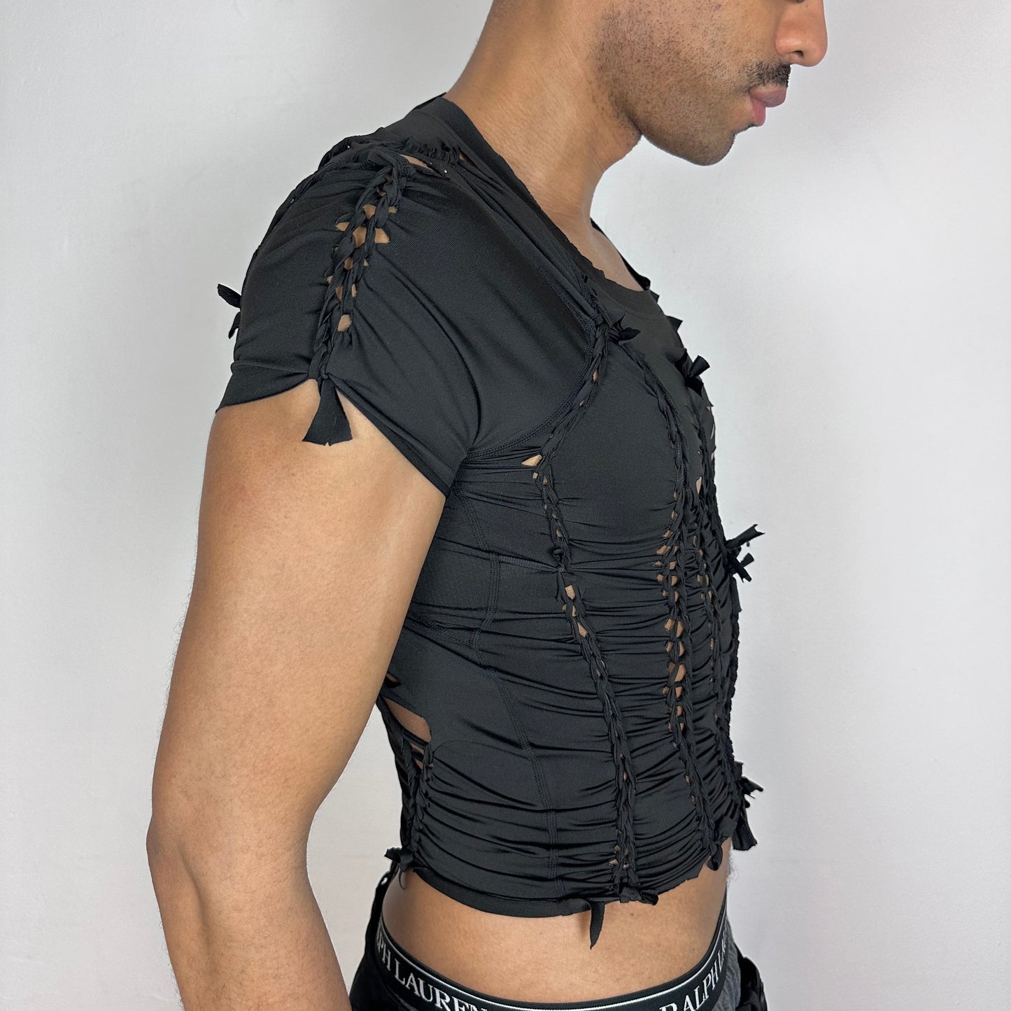 Right side detail of ASTROBOI* 'Pandora' showing braided twist and cut-out construction on slim-fitting black spandex base.