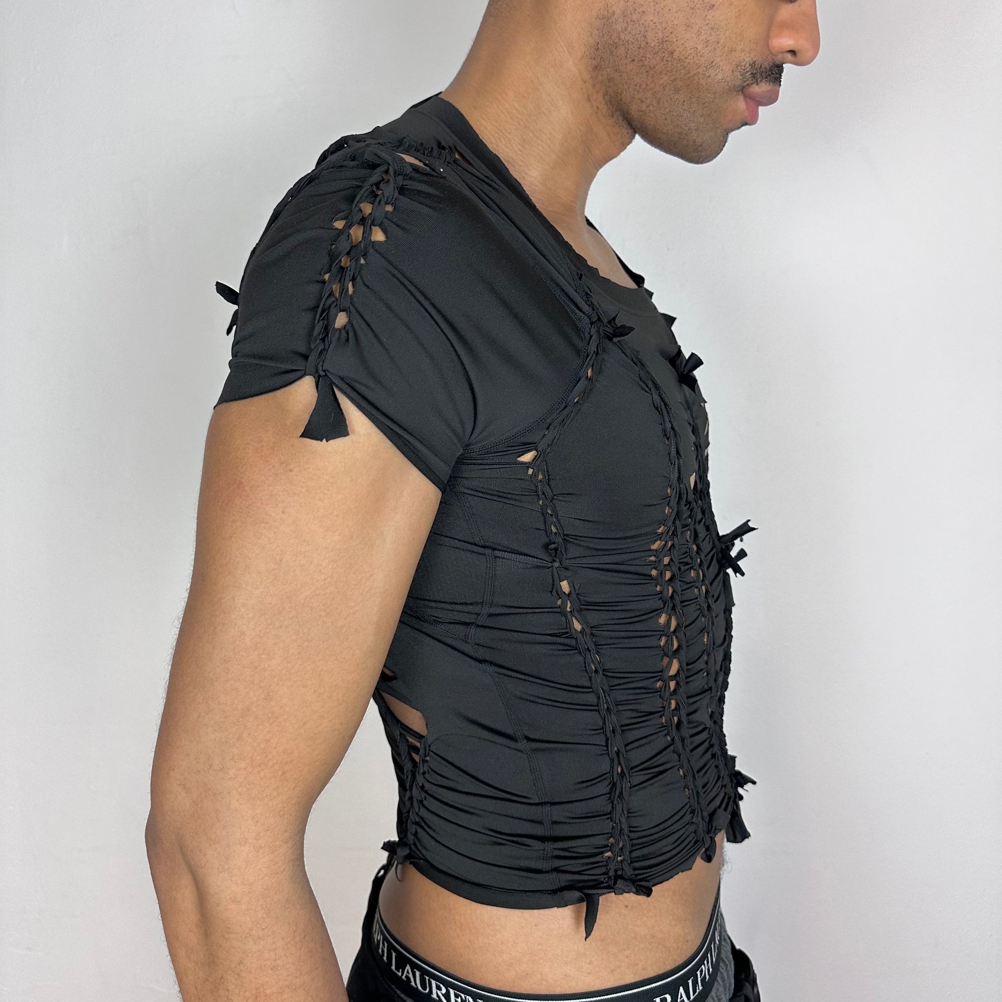 Right side detail of ASTROBOI* 'Pandora' showing braided twist and cut-out construction on slim-fitting black spandex base.