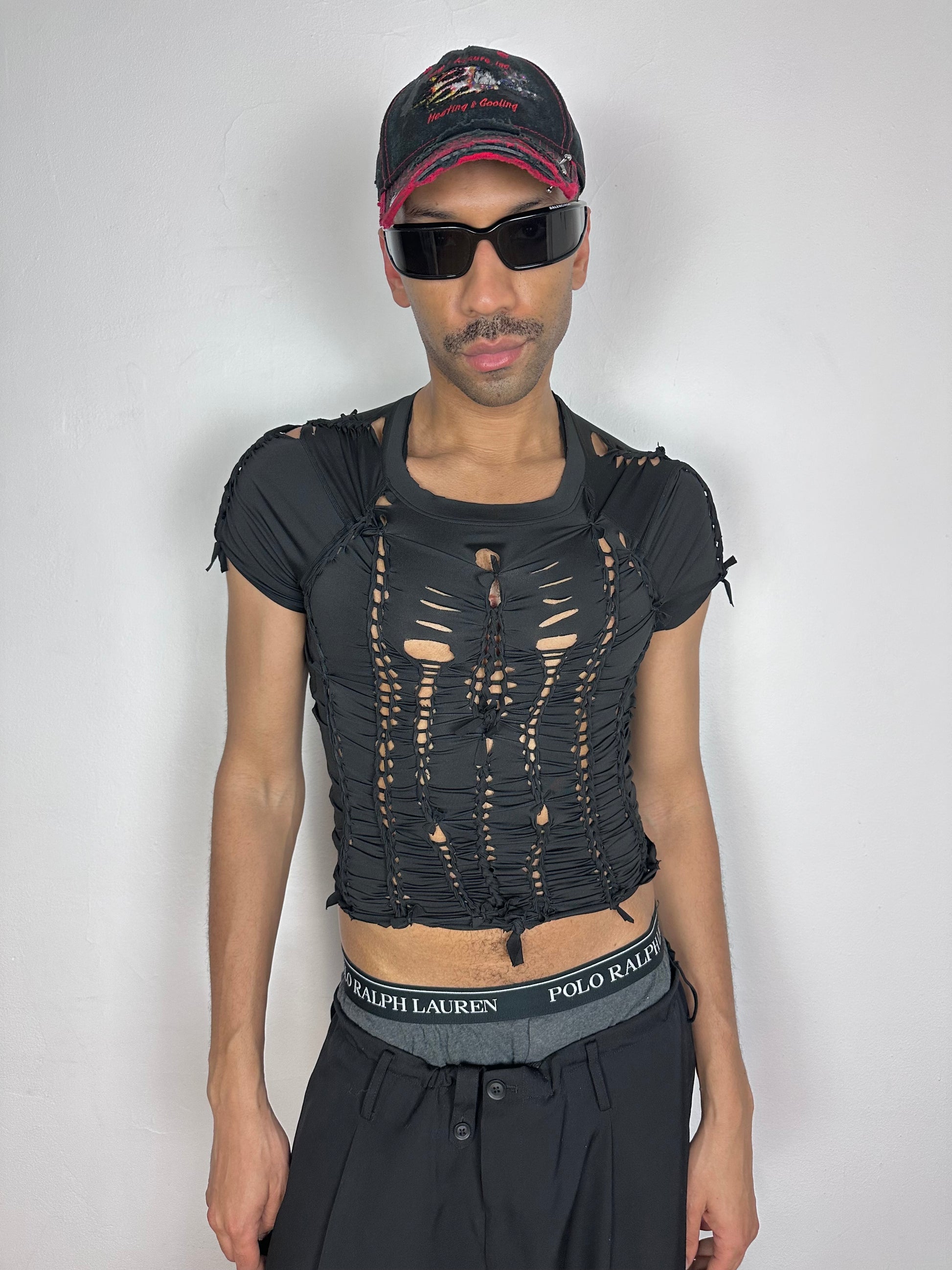 Male model wearing ASTROBOI* 'Pandora' black braided compression crop top, styled full look, ASTROBOI* STUDIO NYC.