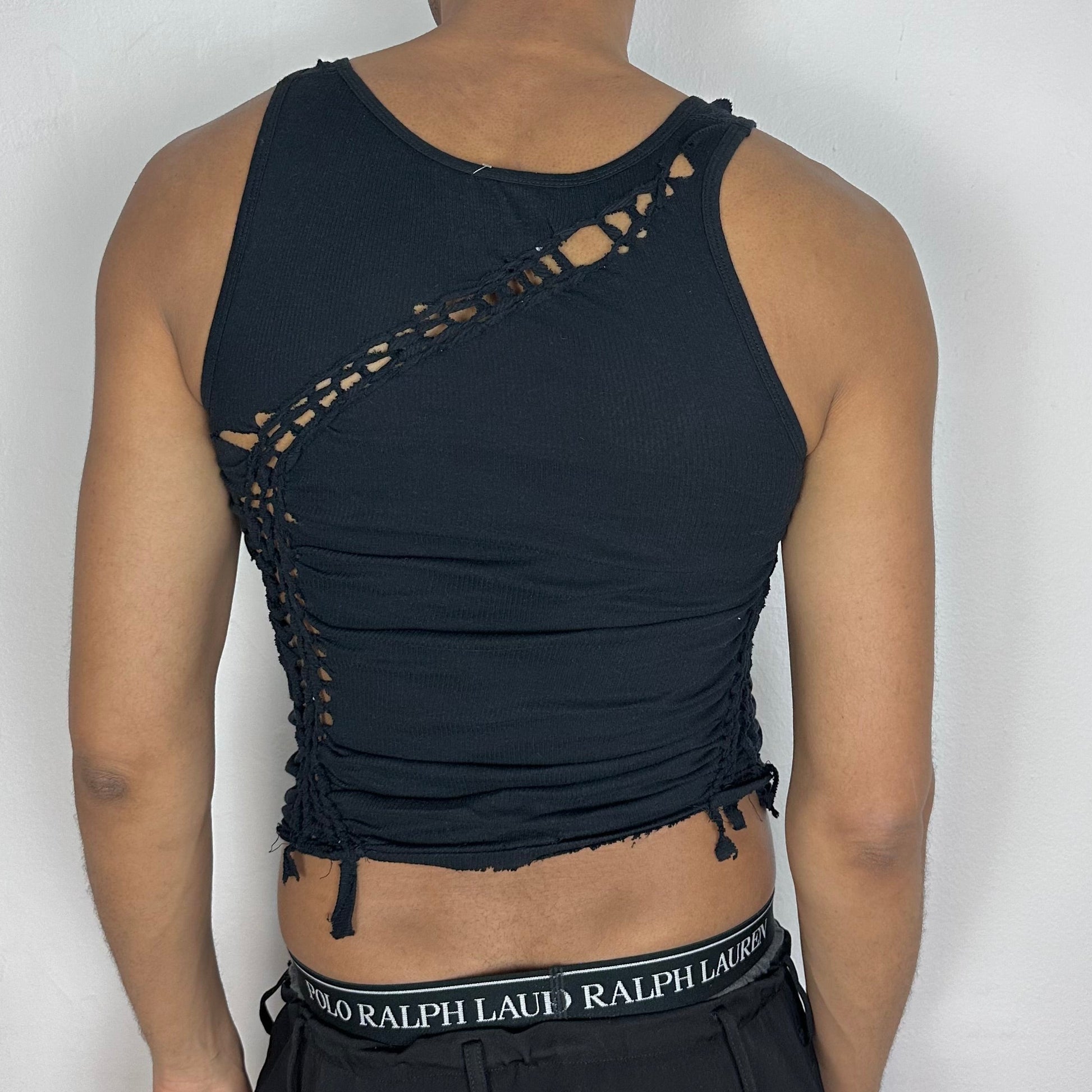 ASTROBOI* 'Morningstar' black braided twist tank top, rear view showing braid, knot, and cut-out construction, worn by male model.