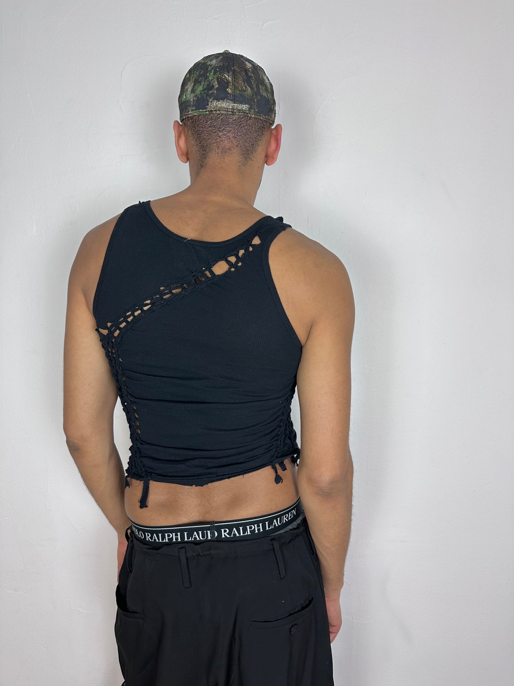 ASTROBOI* 'Morningstar' black braided twist tank top, rear view showing braid, knot, and cut-out construction, worn by male model.