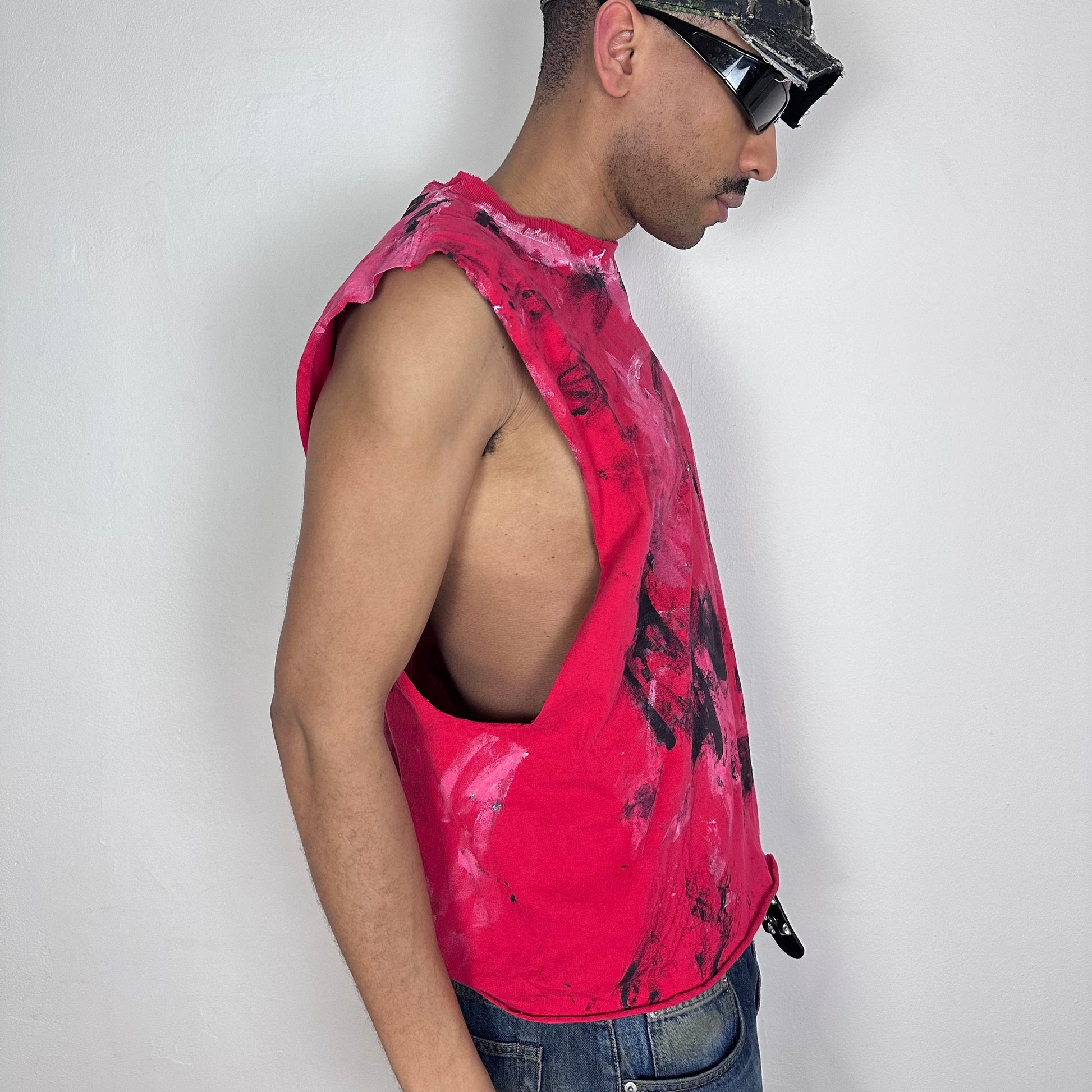 Right side detail of ASTROBOI* 'Hobie' showing white and black paint splatter detailing and raw hem on relaxed-fit red base.