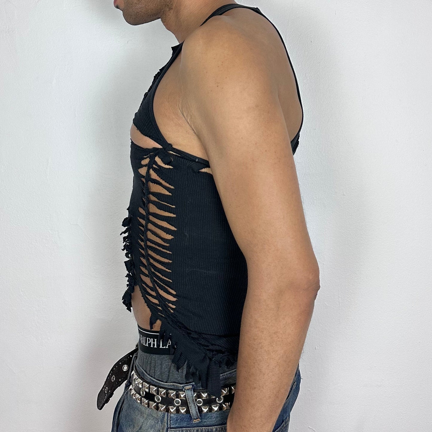 Left side detail of ASTROBOI* 'Highbeam' showing left chest cut-out, hand-braided arrangement, and fringe hem on black tank.