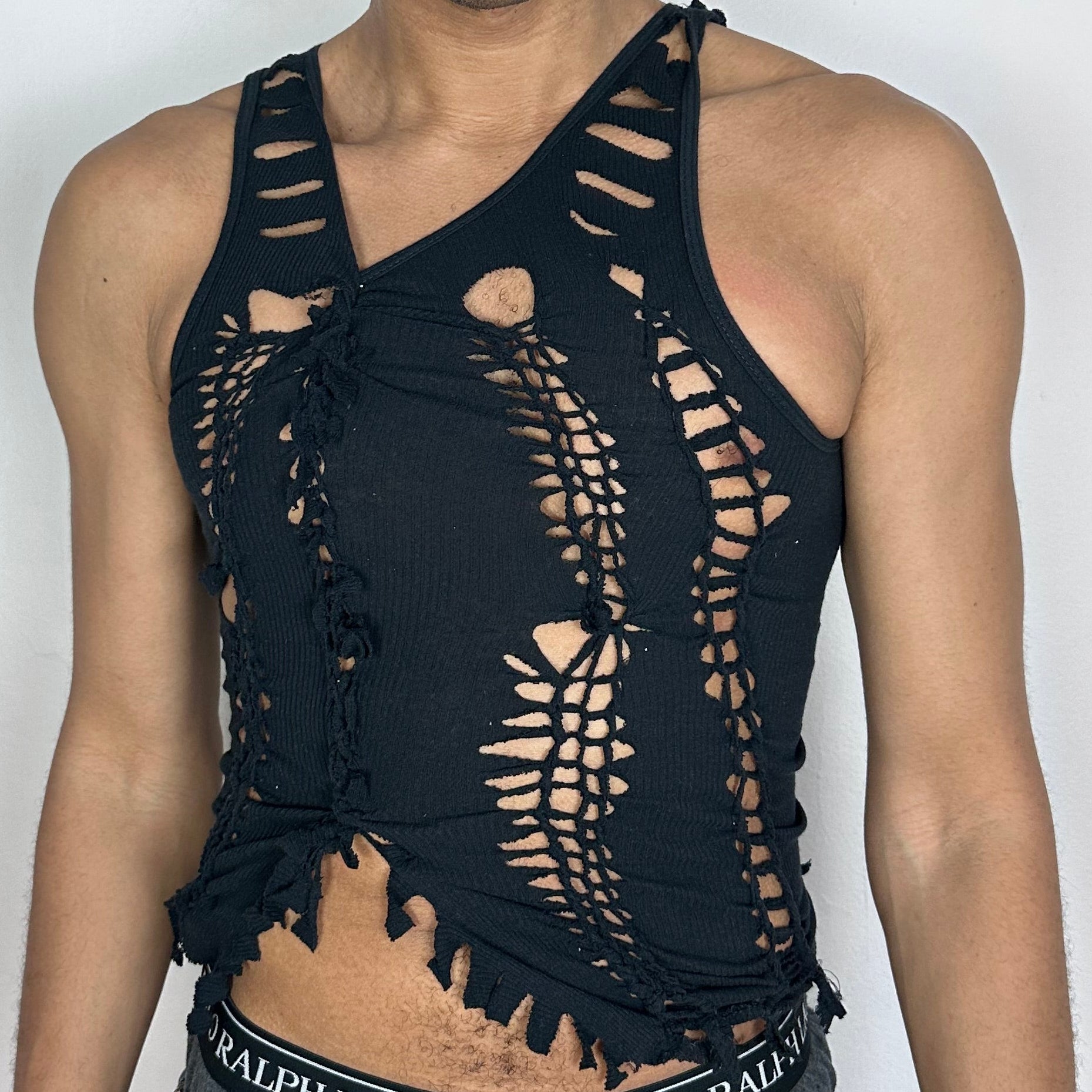 Close-up of ASTROBOI* 'Andromeda' showing hand-braided twist construction and cut-out detailing on black cotton fabric.