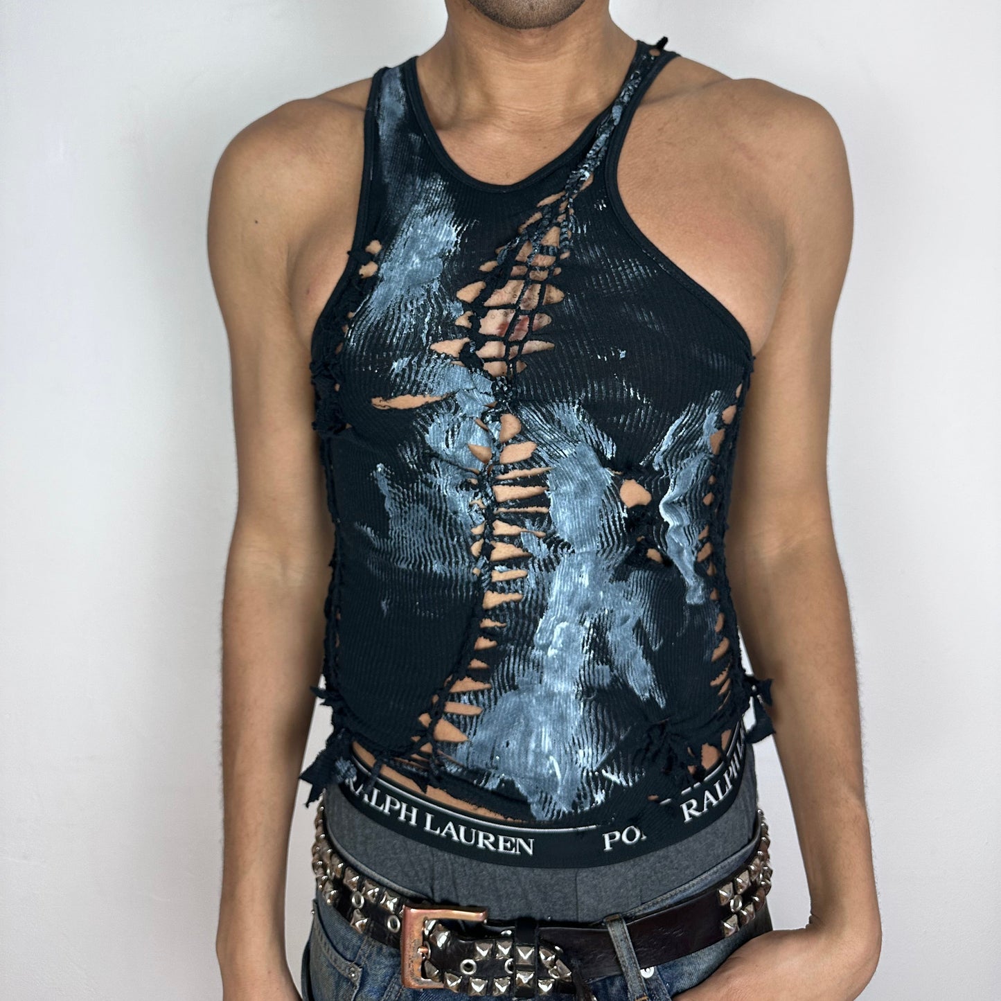 ASTROBOI* 'Shadow Play' black close-fitting braided twist tank top with cut-outs throughout and white paint splatter design, front view.