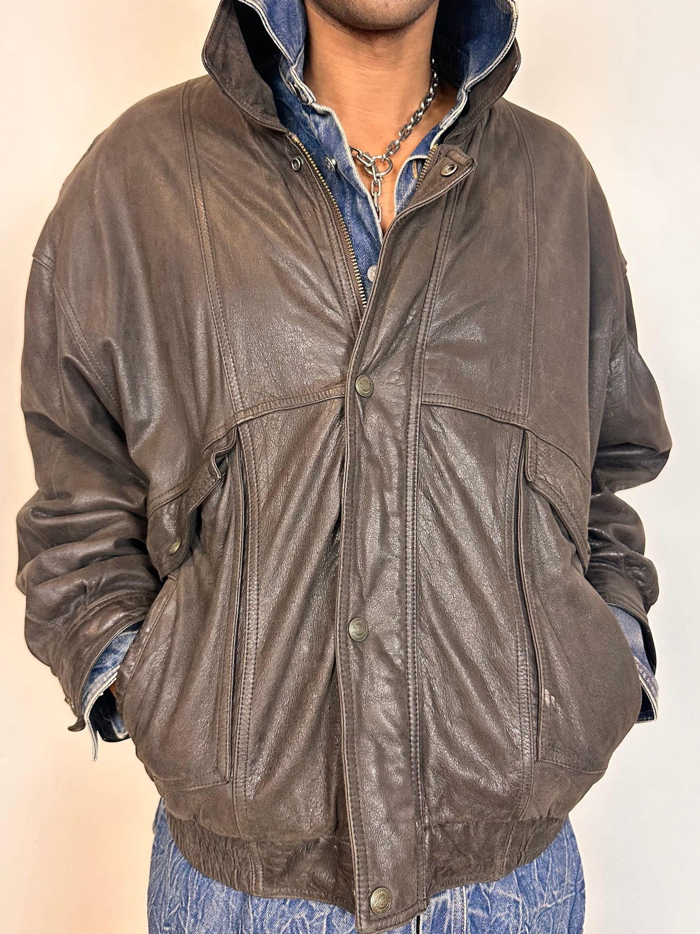 Close up of Vintage Canton Ridge brown leather bomber jacket with ribbed cuffs, elastic hem, relaxed fit, and multiple pockets, fits like XL.