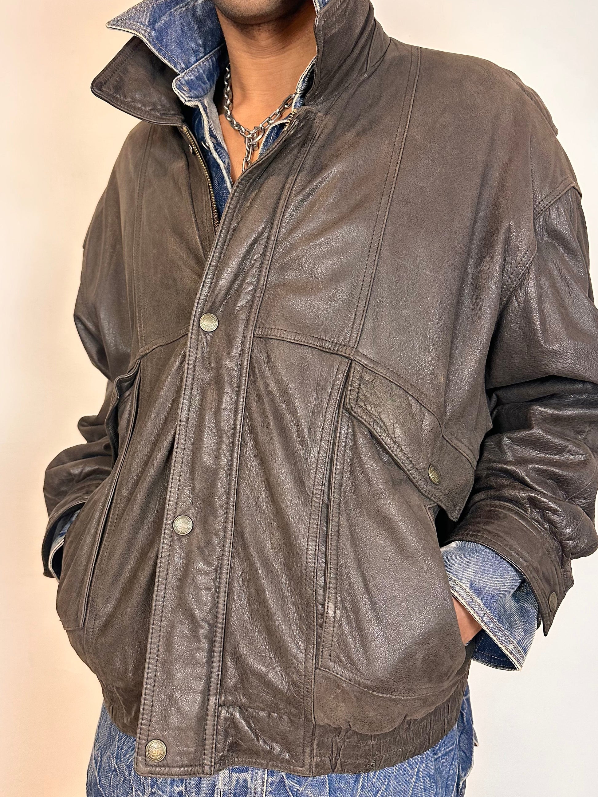 Front detail of Vintage Canton Ridge brown leather bomber jacket with ribbed cuffs, elastic hem, relaxed fit, and multiple pockets, fits like XL.