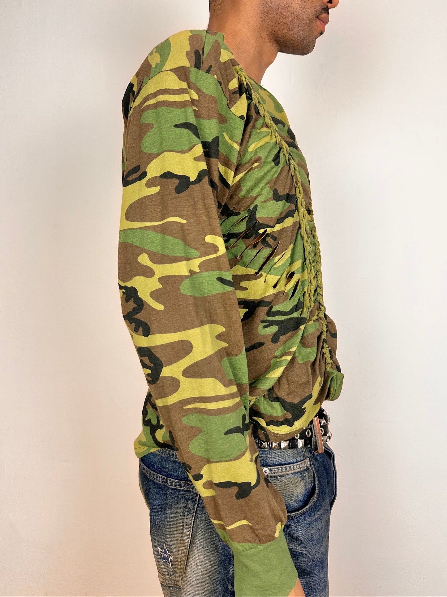 Right side of ASTROBOI* green camouflage T-shirt with braided detailing, tonal rhinestone collar, raw hem, and loose fit, handmade in NYC.