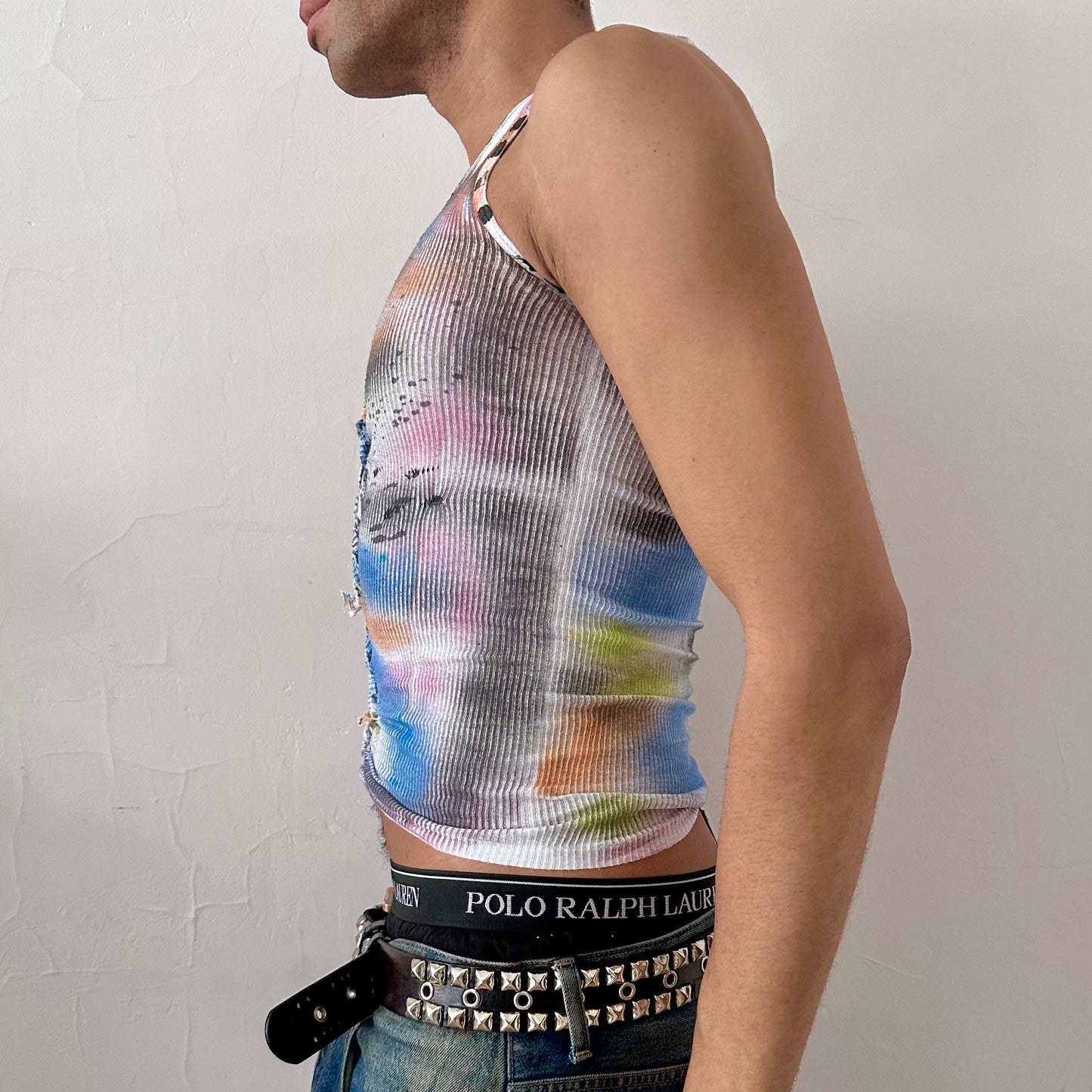 Left side detail of ASTROBOI* x Hanes 'Counting Crows' showing hand-braided arrangement and multicolored abstract paint design on white cotton tank.