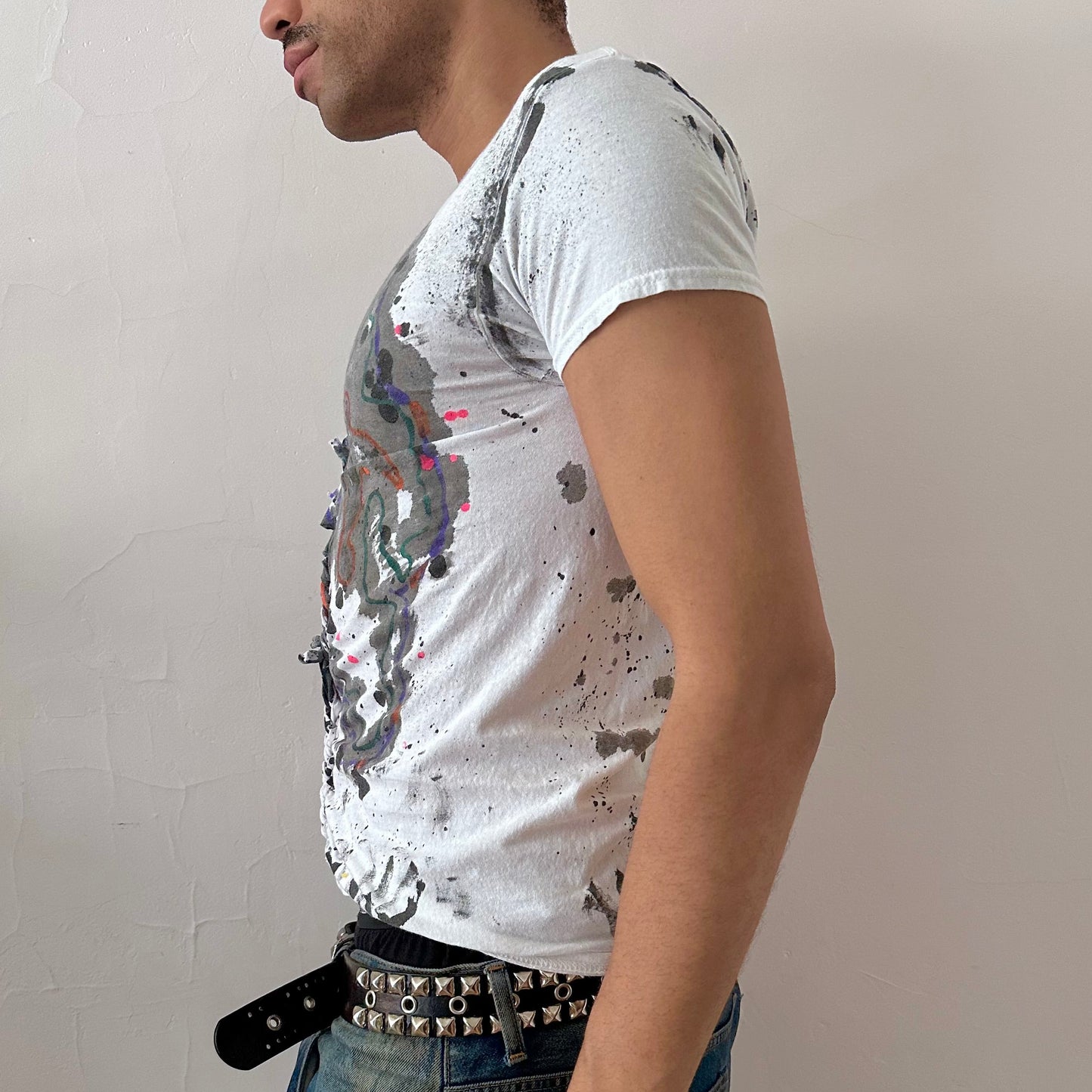 Left side detail of ASTROBOI* x Hanes 'Multicolor' showing hand-painted scribble confetti design and center braid detailing on white graphic tee.