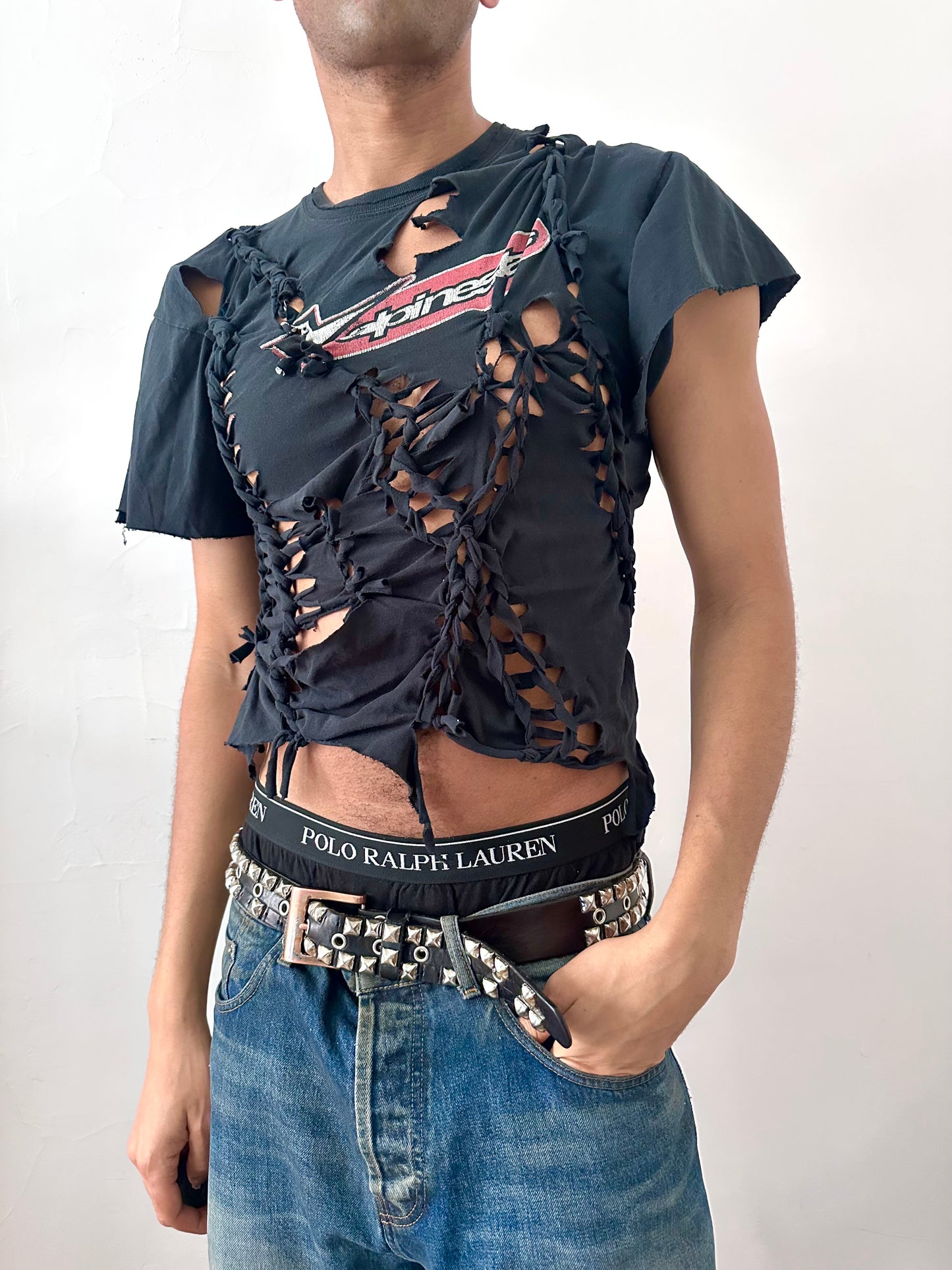 Male model wearing ASTROBOI* x Alpinestars black braided cut-out t-shirt, styled full look, ASTROBOI* STUDIO NYC.