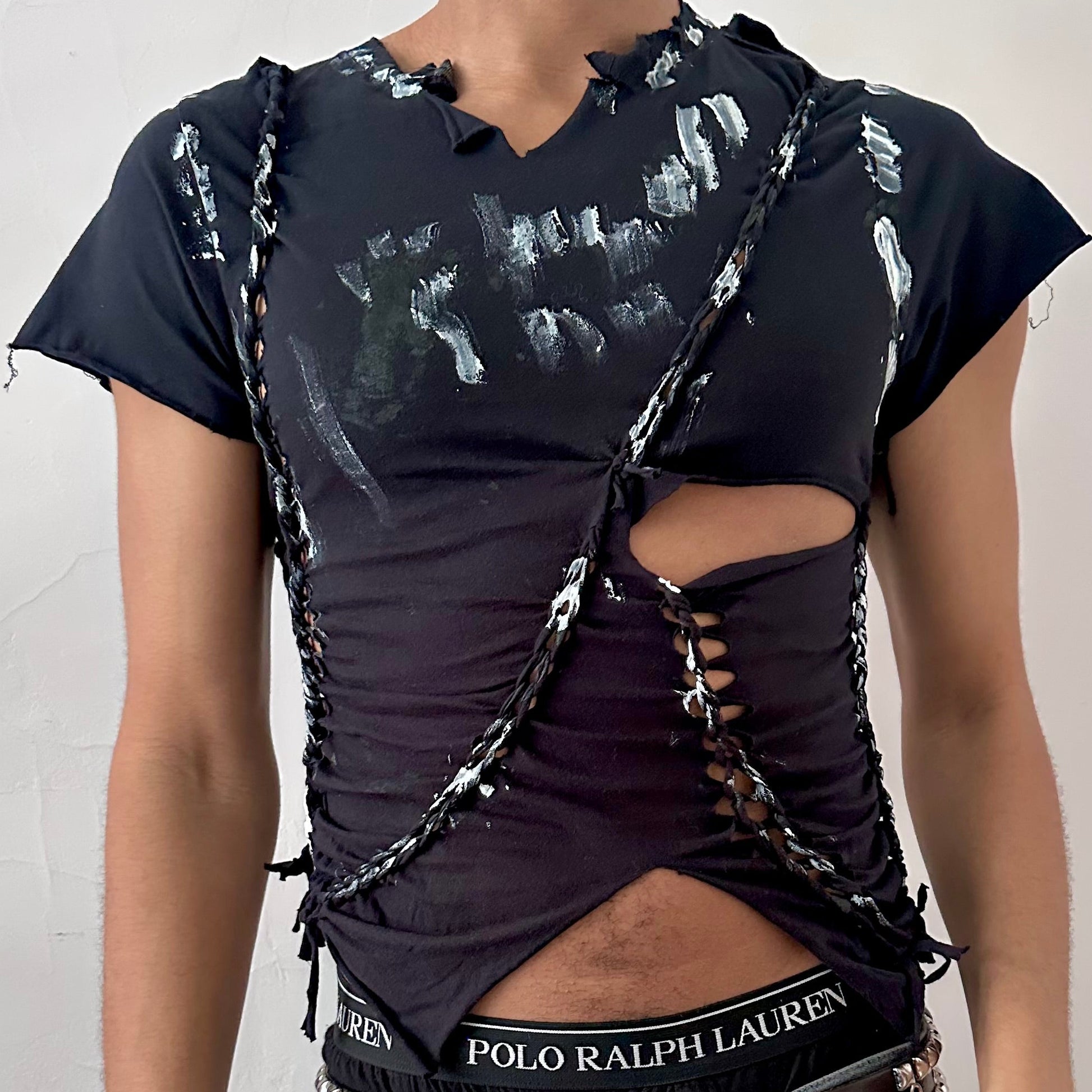 Close-up of ASTROBOI* 'Duality' showing hand-braided construction, cut-out detailing, and white paint on braid detail on black fabric.