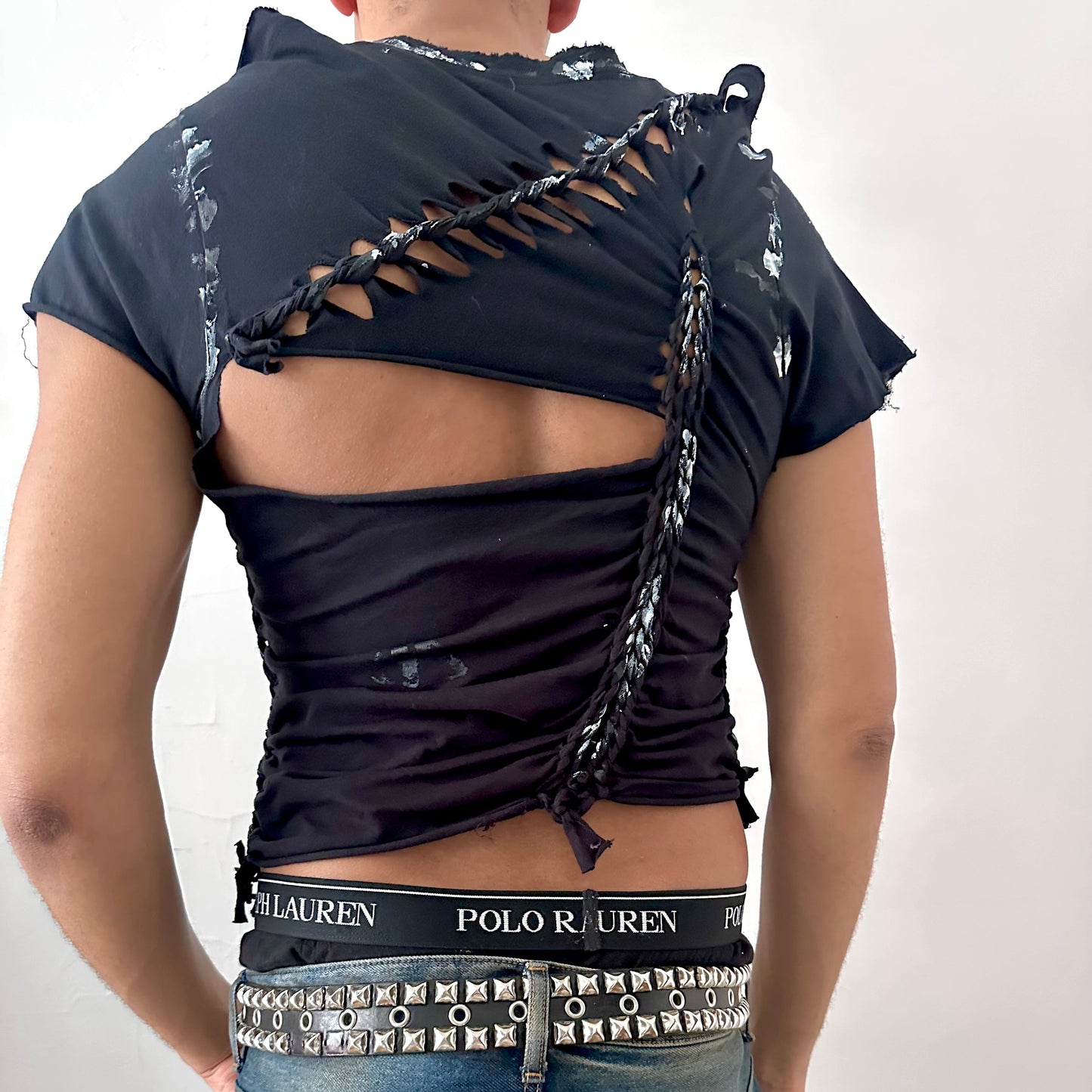 ASTROBOI* 'Duality' black braided twist t-shirt, rear view showing braid, cut-out, and white paint detail construction, worn by male model.