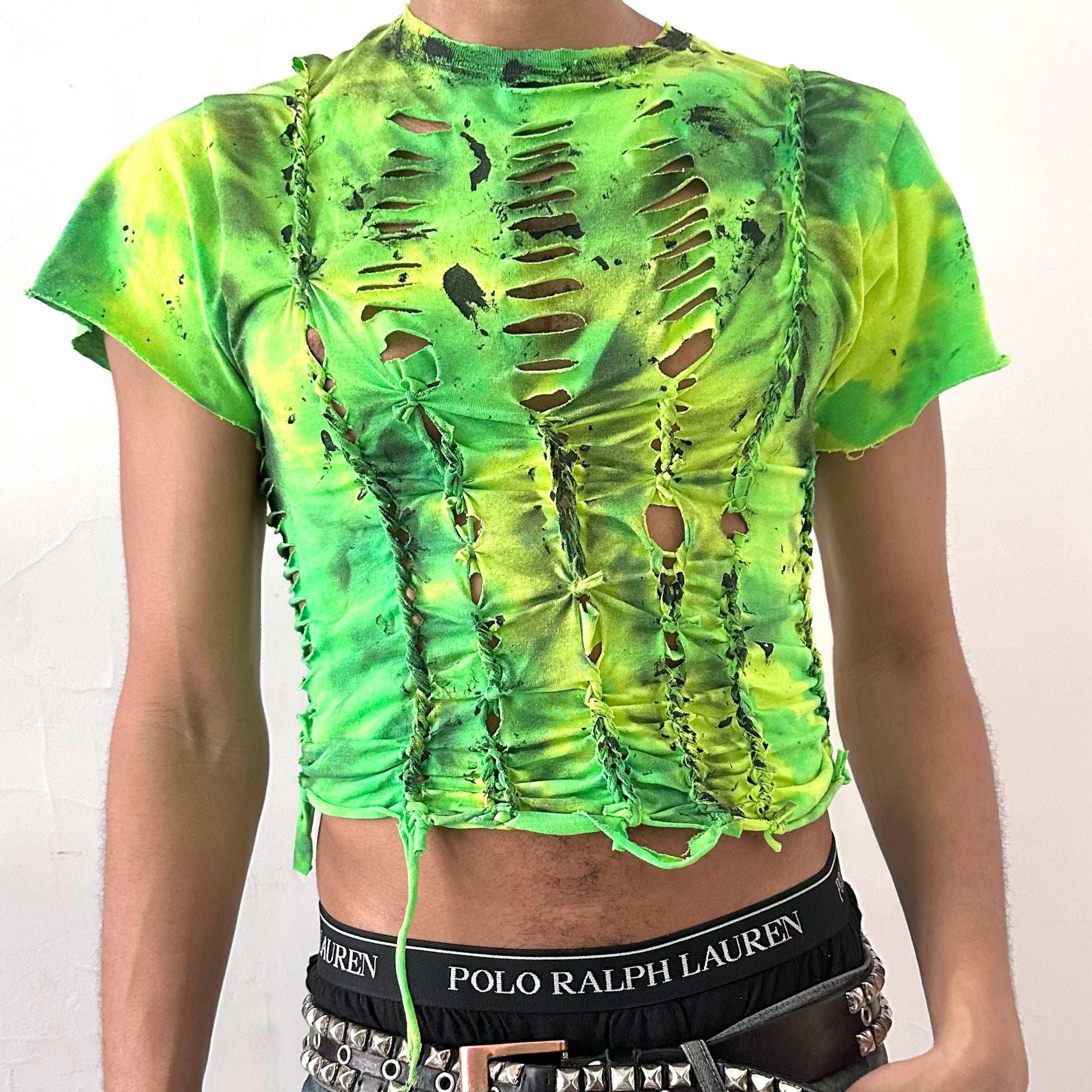 Close-up of ASTROBOI* x Gildan 'Sage Pulse' showing neon monochromatic green tie dye, hand-braided construction, and black tar paint detailing on cotton fabric.