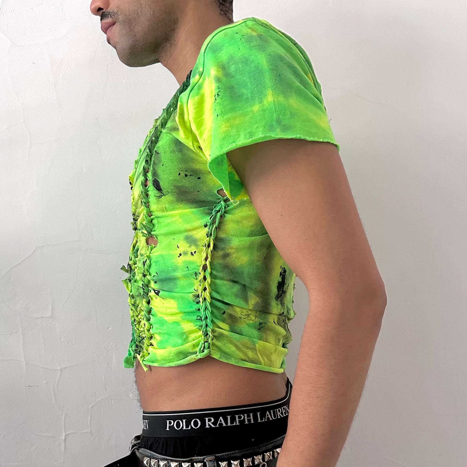 Left side detail of ASTROBOI* x Gildan 'Sage Pulse' showing hand-braided construction, neon green tie dye, and black tar paint detailing on cotton tee.
