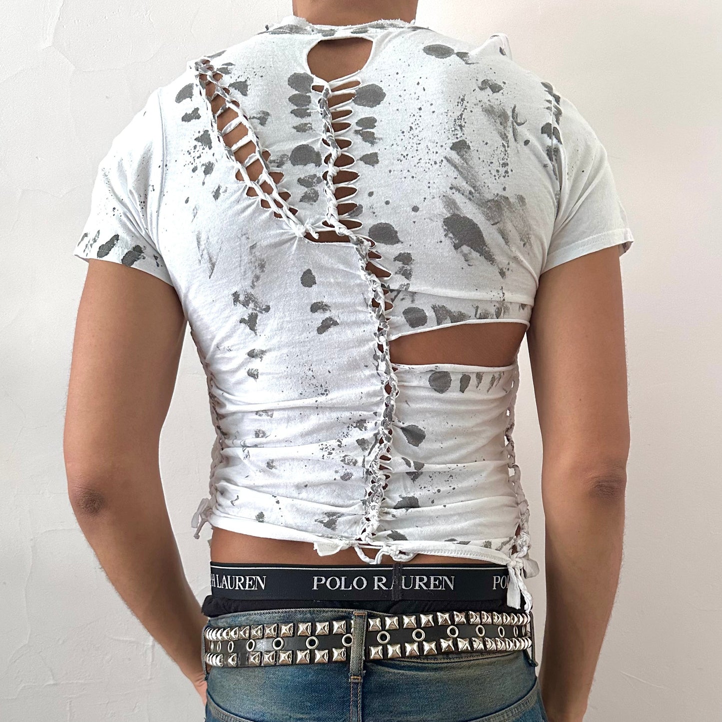 ASTROBOI* x Gildan '1001' white braided twist t-shirt, rear view showing braid, cut-out, and black painted pattern construction, worn by male model.
