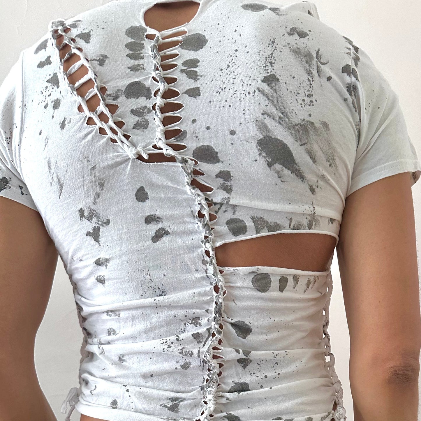 ASTROBOI* x Gildan '1001' white braided twist t-shirt, rear view showing braid, cut-out, and black painted pattern construction, worn by male model.