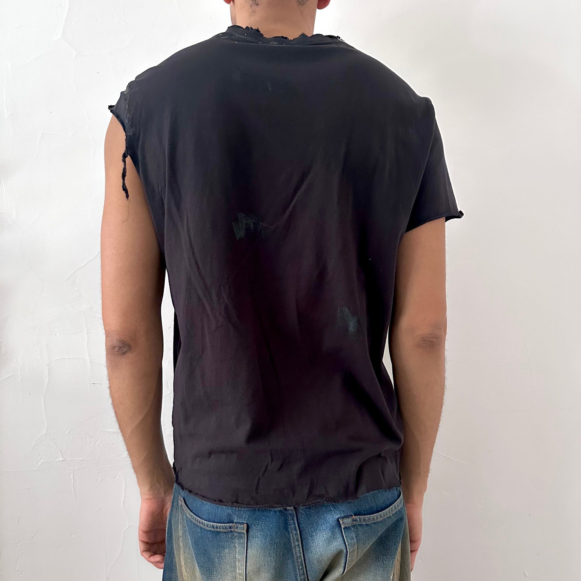 ASTROBOI* x CK Jeans black asymmetric logo t-shirt, rear view showing asymmetric sleeve and uneven hem construction, worn by male model.