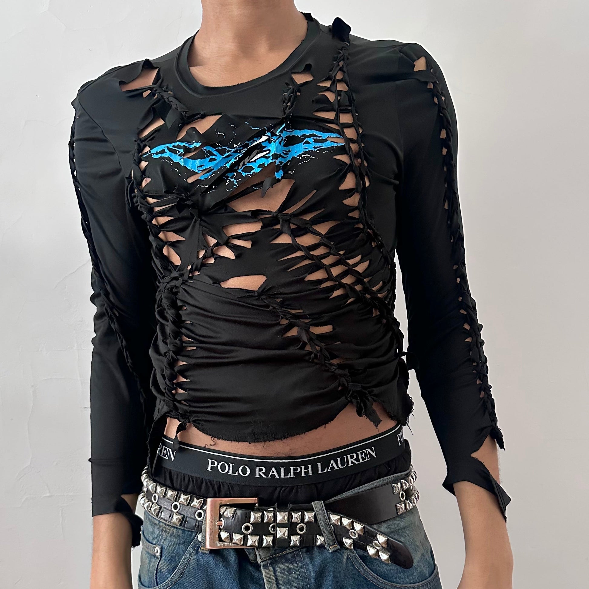 ASTROBOI* 'Thunder' black slim-fitting braided compression top with hand-braided arrangement, cut-outs, blue and white lightning graphic at center chest, and raw hem, front view.