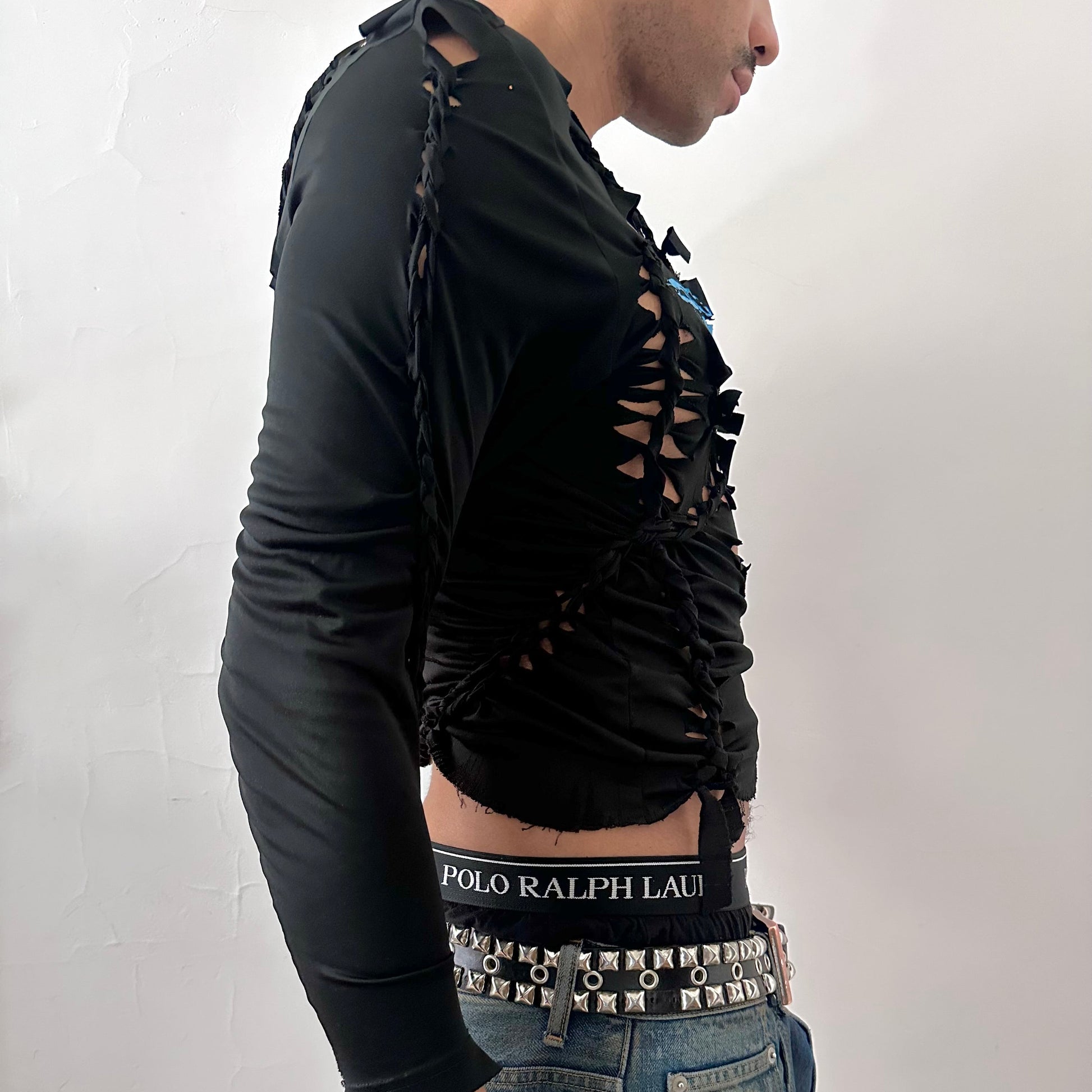 Right side detail of ASTROBOI* 'Thunder' showing braided twist, cut-out construction, and raw hem on slim-fitting black Lycra base.