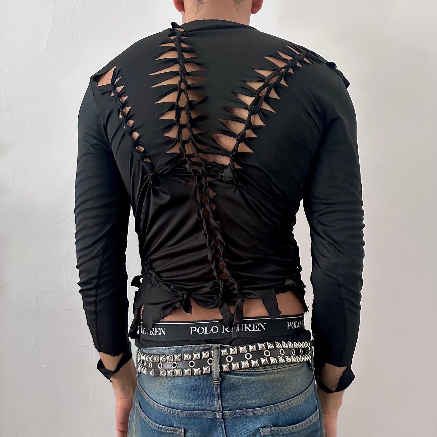 ASTROBOI* 'Thunder' black braided compression top, rear view showing braid, cut-out, and raw hem construction, worn by male model.