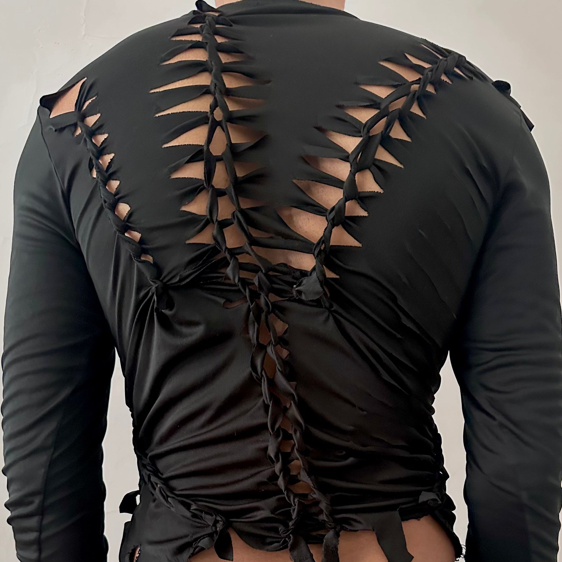 ASTROBOI* 'Thunder' black braided compression top, rear view close up showing braid, cut-out, and raw hem construction, worn by male model.