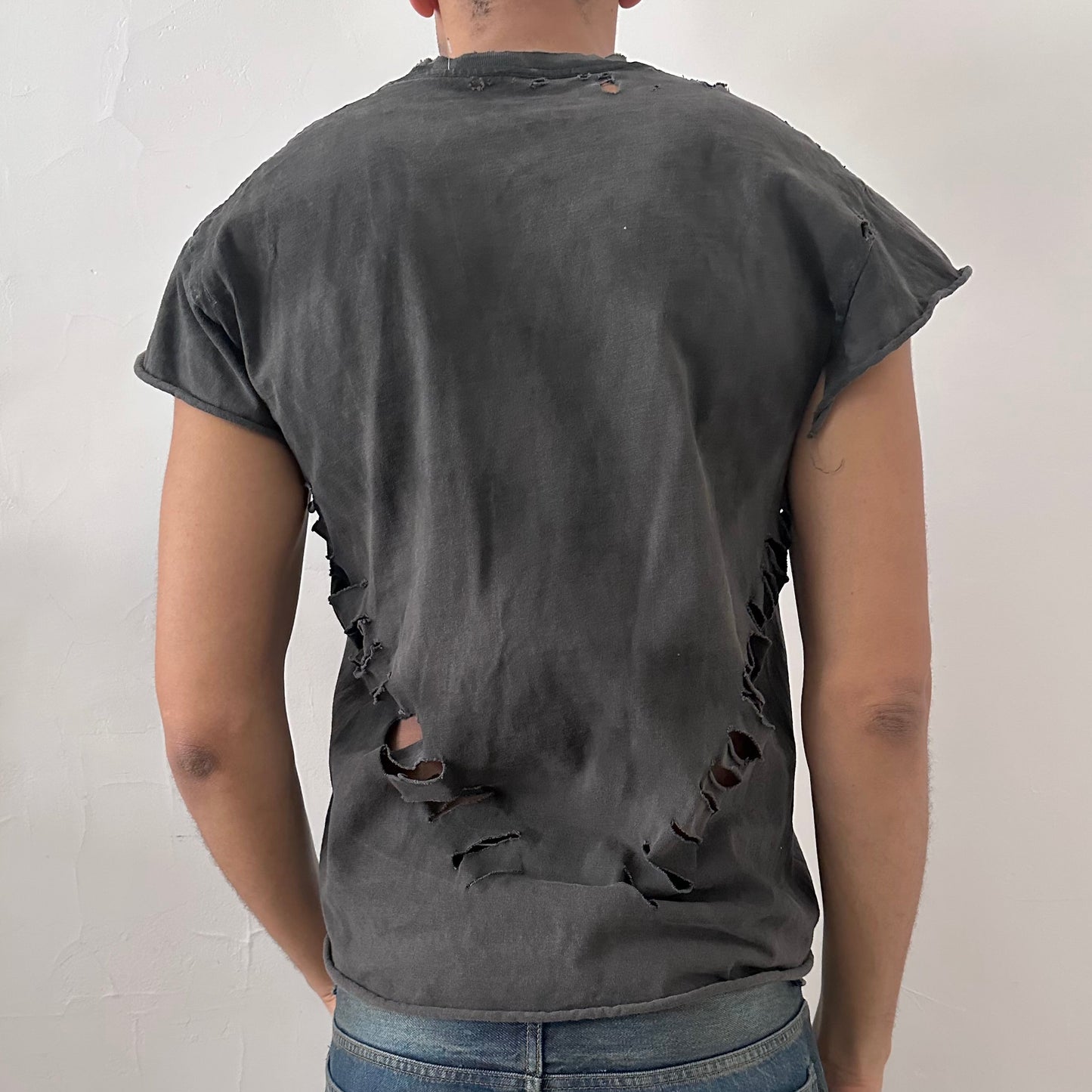 ASTROBOI* NCAA Basketball black ripped muscle tank top, rear view showing distressed holes and raw edge construction, worn by male model.