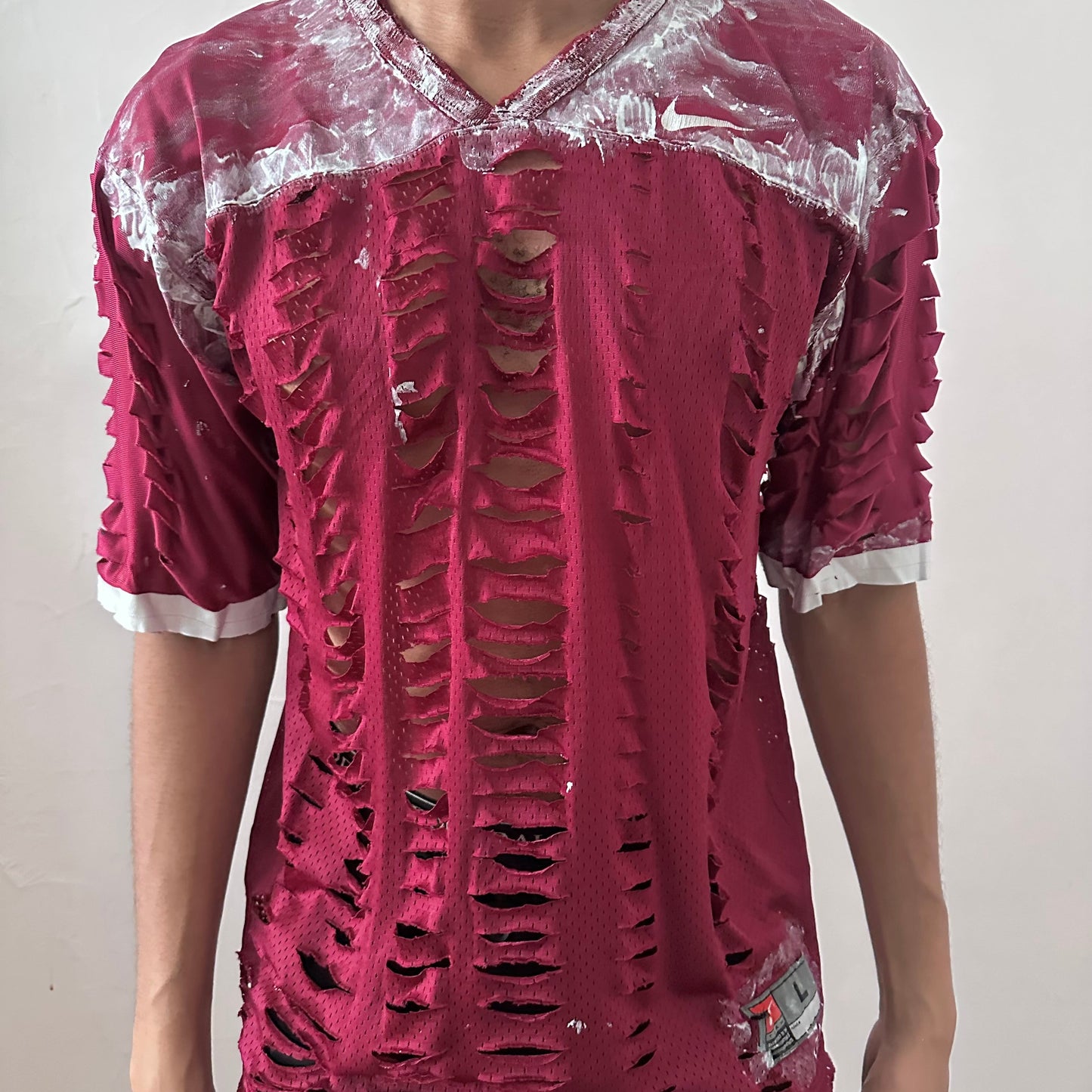  Close-up of ASTROBOI* x Nike 'BloodThirst' showing white painterly detail on breathable maroon mesh fabric and raw hem finish.