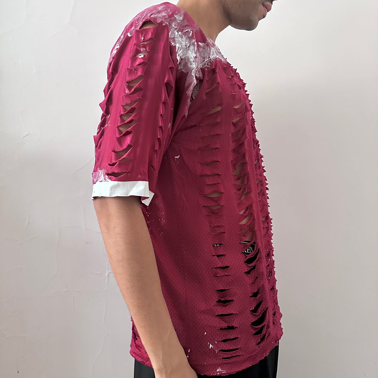  Right side detail of ASTROBOI* x Nike 'BloodThirst' showing white painterly detailing on breathable maroon mesh and raw hem construction.