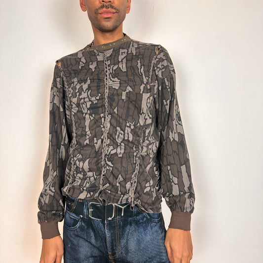 Front of ASTROBOI* gray camouflage long sleeve T-shirt with braided torso detailing, rhinestone neckline, raw hem, and chest pocket, handmade in NYC.