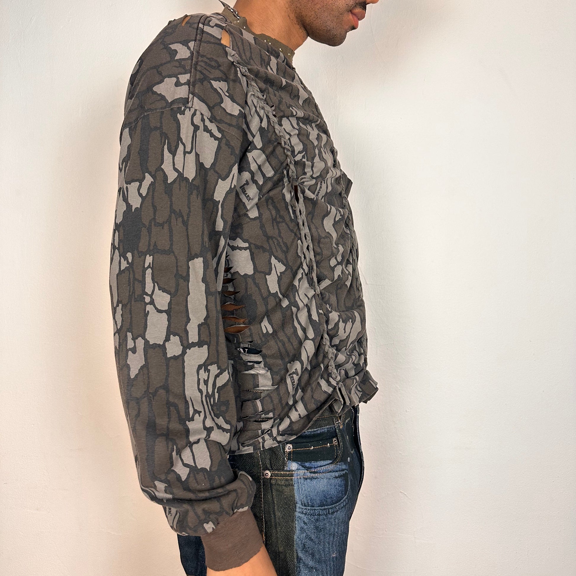 Right side of ASTROBOI* gray camouflage long sleeve T-shirt with braided torso detailing, rhinestone neckline, raw hem, and chest pocket, handmade in NYC.