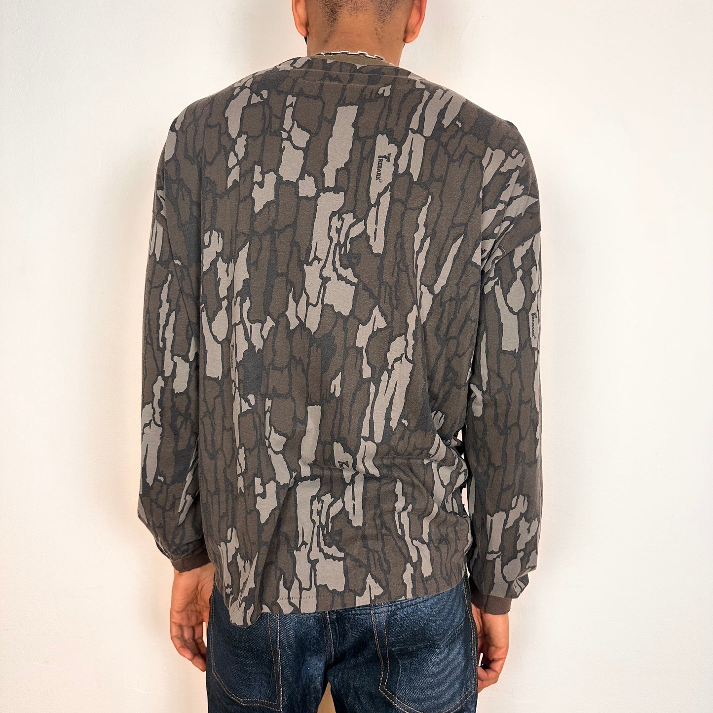 Back of ASTROBOI* gray camouflage long sleeve T-shirt with braided torso detailing, rhinestone neckline, raw hem, and chest pocket, handmade in NYC.