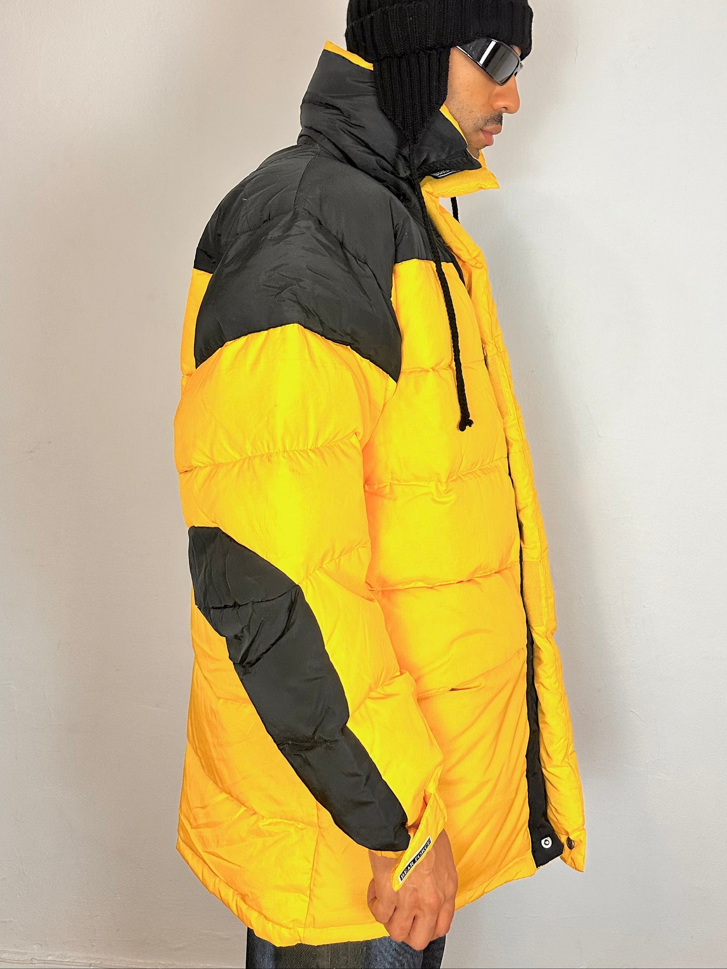 Right side of Bear Mountain yellow puffer jacket with oversized architectural fit, chest logo detail, super warm insulation, size XL.