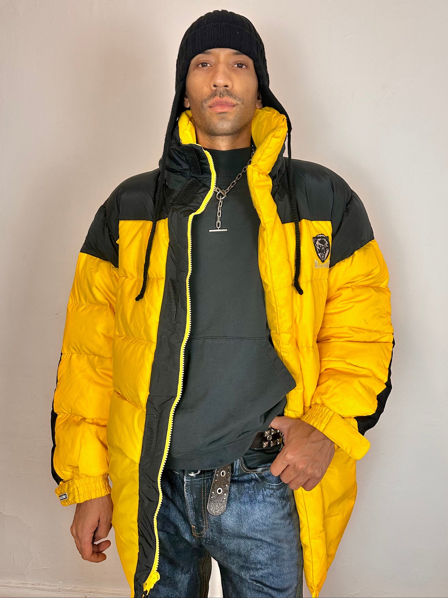 Styled image of Bear Mountain yellow puffer jacket with oversized architectural fit, chest logo detail, super warm insulation, size XL.