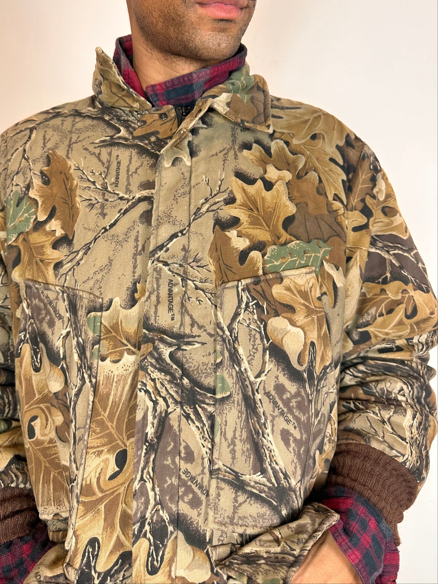 Close up on Vintage brown RealTree camouflage quilted jacket with insulated lining, knit cuffs, four front pockets, boxy fit, size XL.