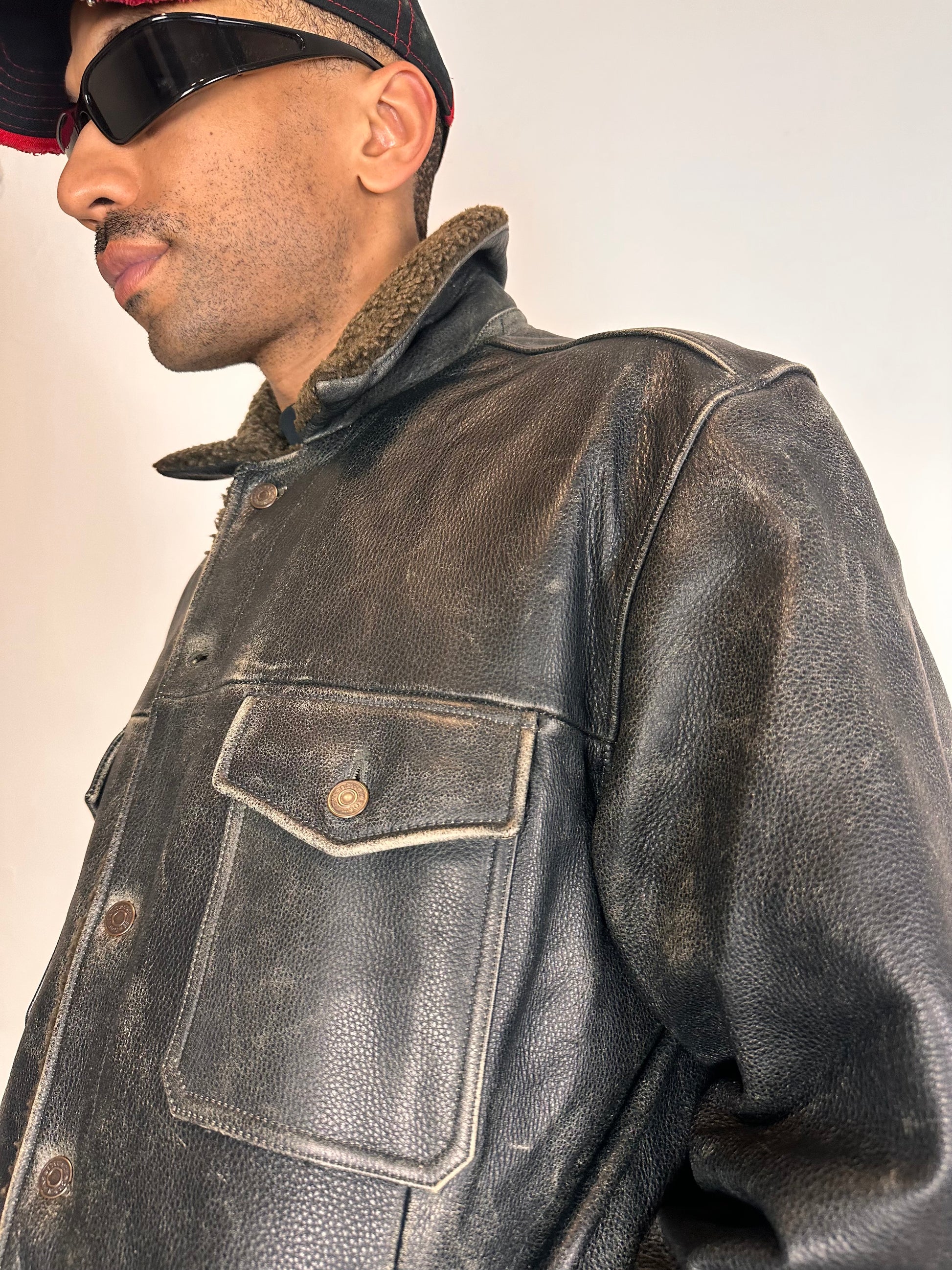Side close up on Vintage GAP blackish-brown leather shearling jacket with sherpa collar and interior, chest and hip pockets, rugged fatigued finish, size XL.