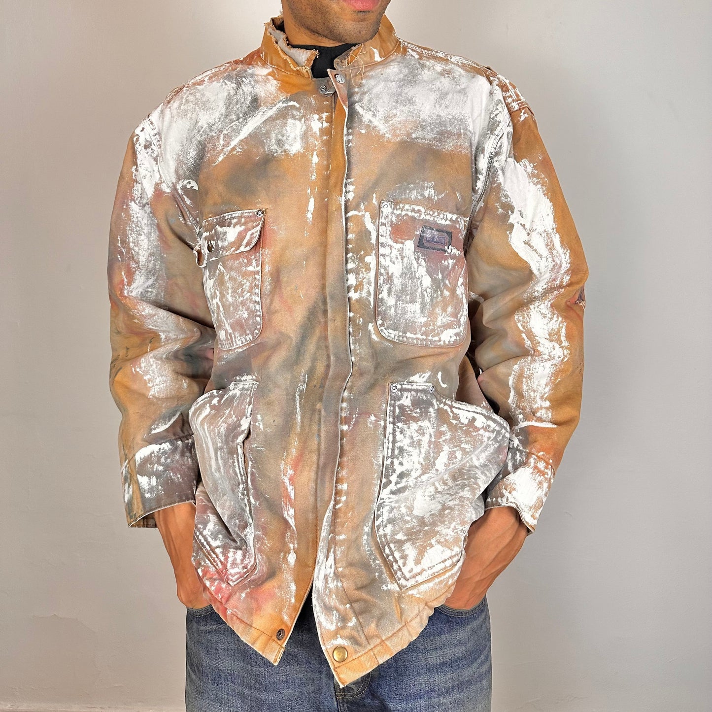 Front of ASTROBOI* Big Smith tan workwear jacket with quilted lining, boxy fit, deconstructed collar, and black red white paint detailing, size XL.