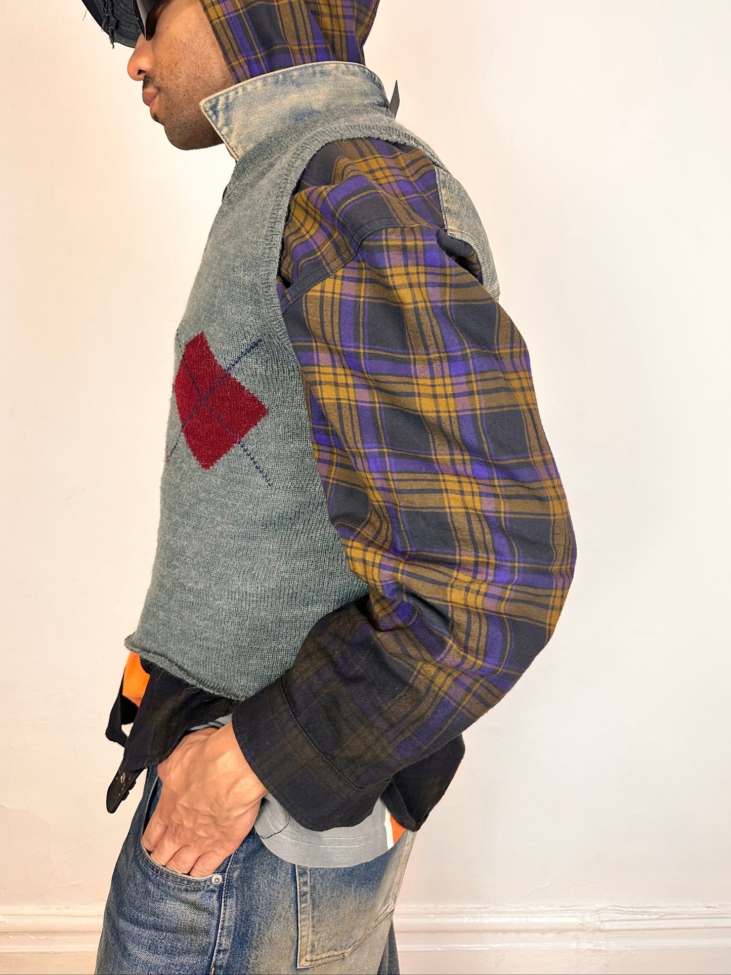 Left side of ASTROBOI* gray cropped argyle sweater vest in size Large with burgundy and purple pattern, raw hem, and relaxed fit. Custom made in NYC.