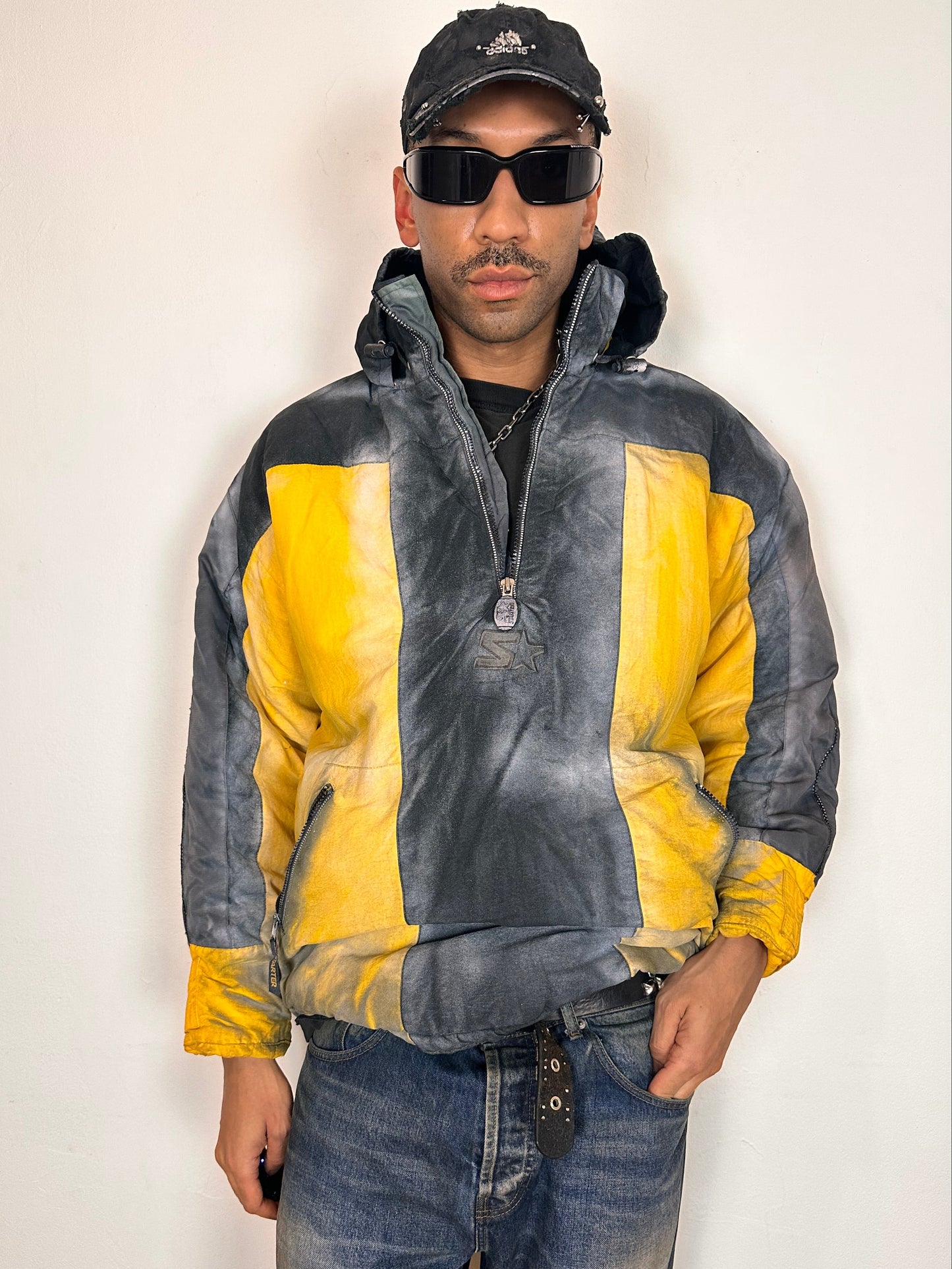 Styled view of ASTROBOI* x Starter yellow and black airbrushed puffer jacket with grey sleeves, reflective taping, and adjustable toggles, men’s XL.