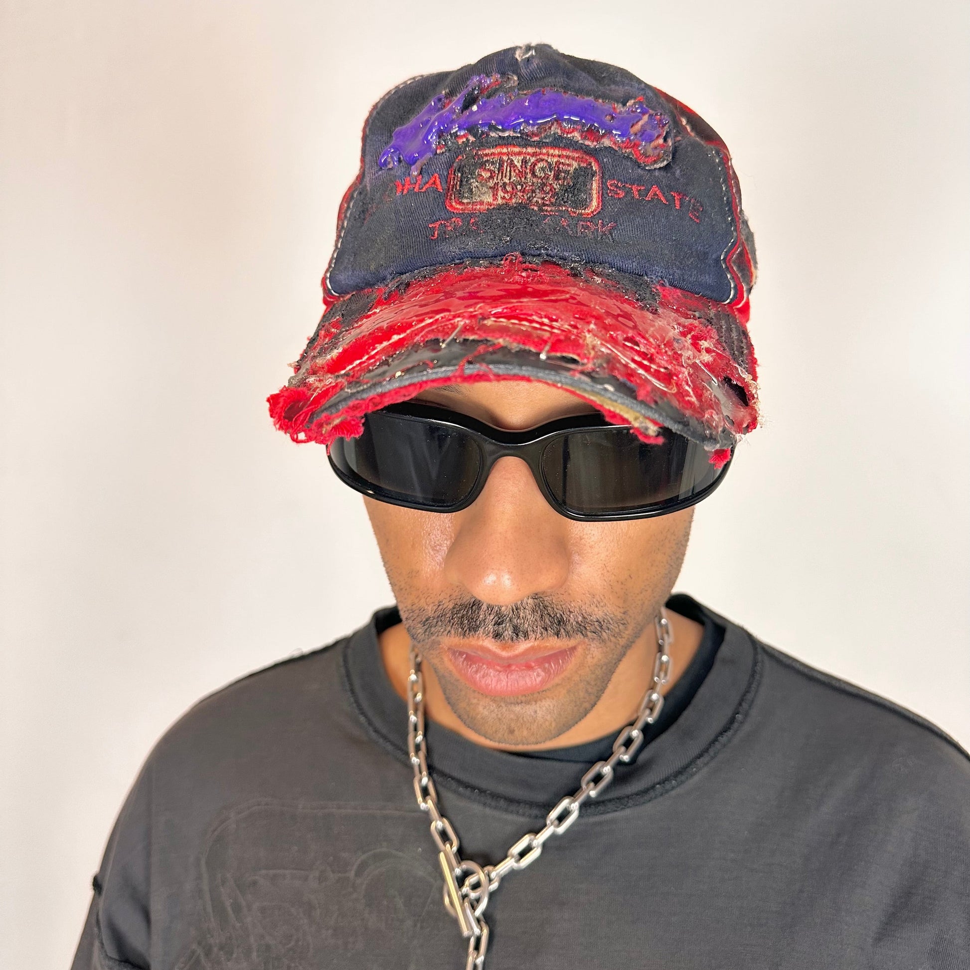 Front overview of Blue and red ASTROBOI* hat featuring a purple resin-coated Hawaii graphic, deconstructed visor with clear resin, and black painted accents.